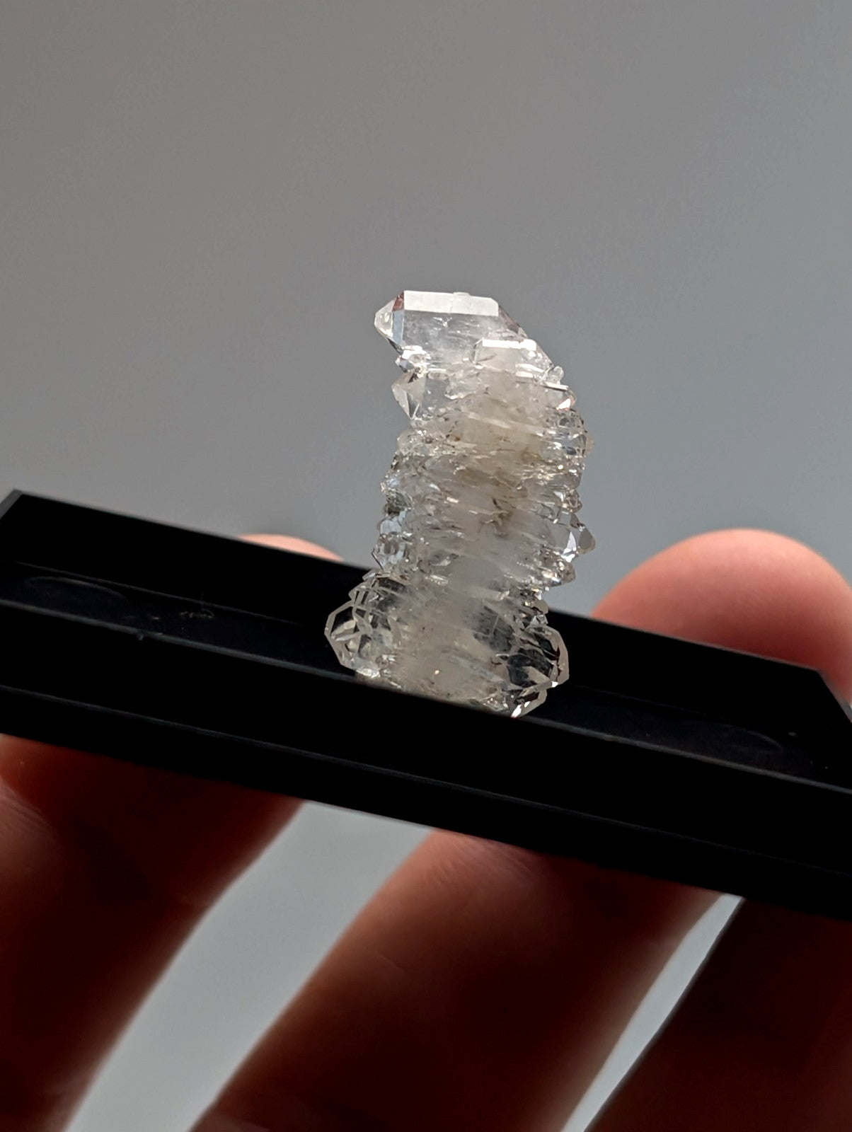 A clear quartz crystal cluster with jagged layers and subtle inclusions in a photo case mount from saline county arkansas usa