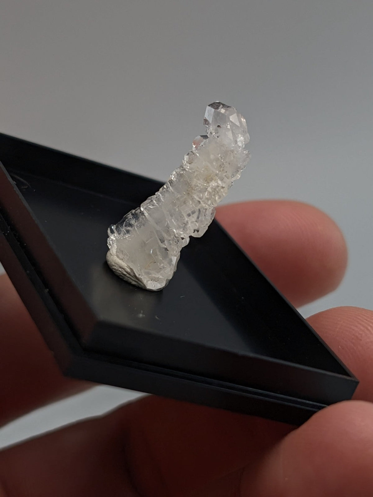 A translucent faden quartz crystal with jagged clear facets in a photo case from saline county arkansas usa