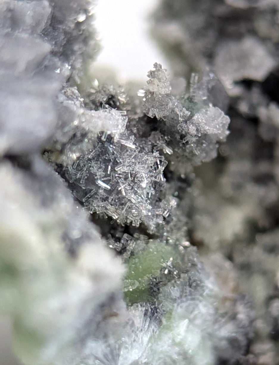 A cluster of translucent, crystalline minerals with sharp, interlocking facets and a faint grayish tint.