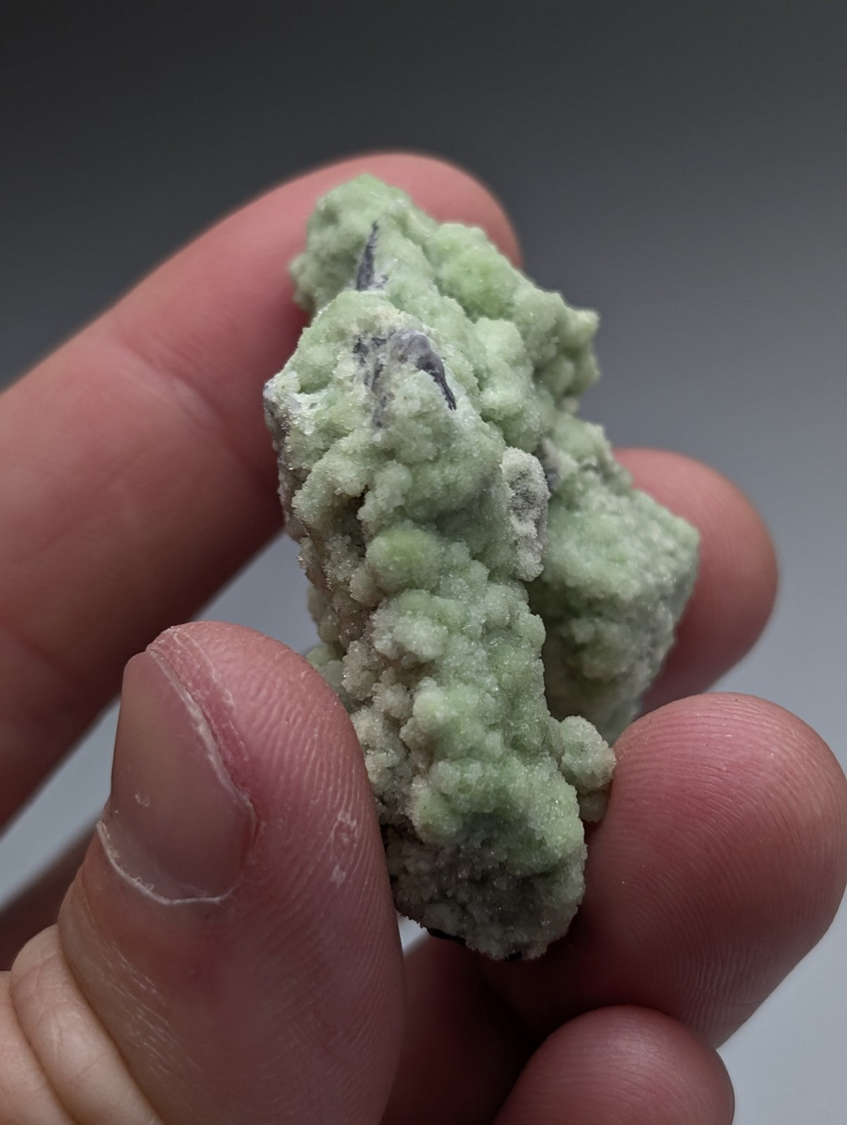 A pale green fluorwavellite mineral specimen with crystalline texture and darker inclusions intermixed with siO2 from Mauldin Mountain Arkansas