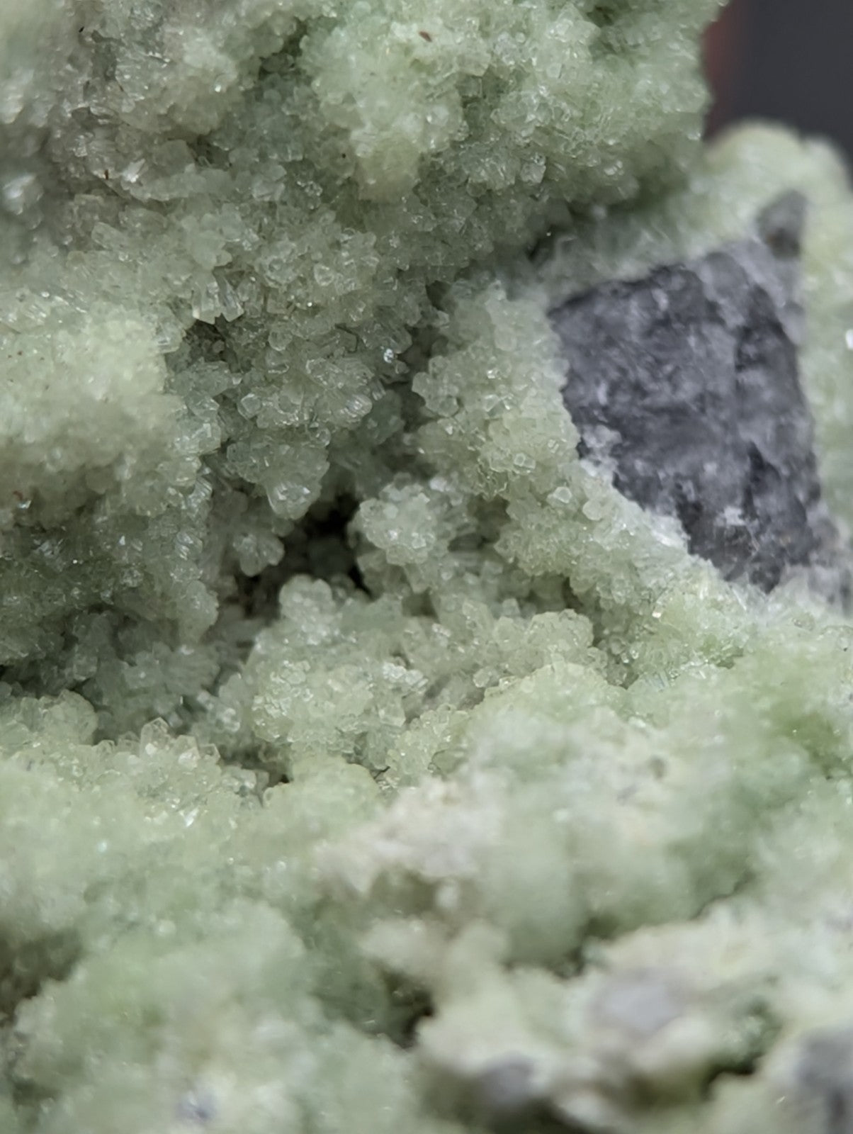 A cluster of translucent pale green fluorwavellite crystals intermixed with sio2 and a grayish inclusion from mauldin mountain arkansas