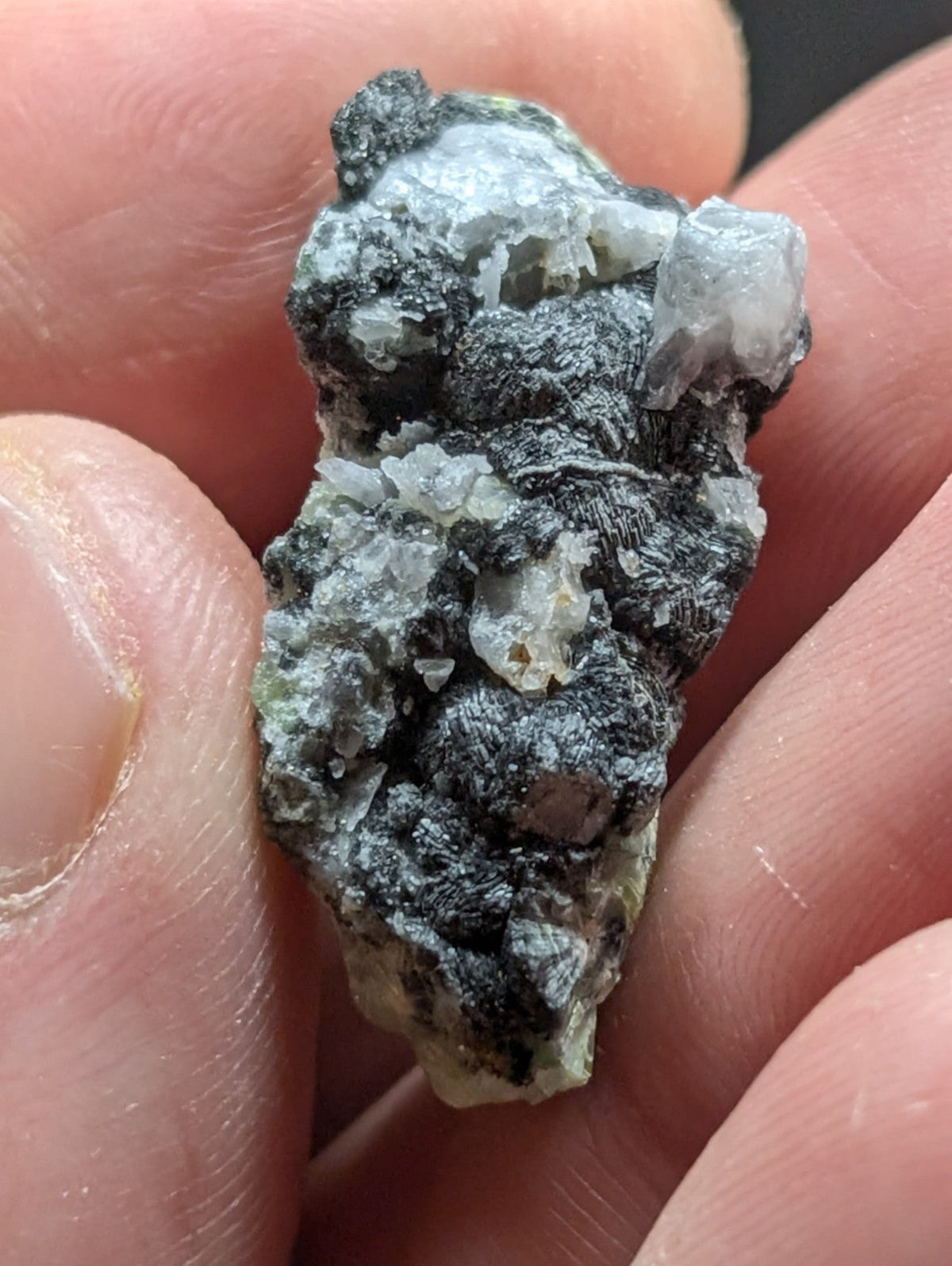 A rough, irregularly shaped mineral specimen featuring a mix of dark gray and translucent white crystalline formations.