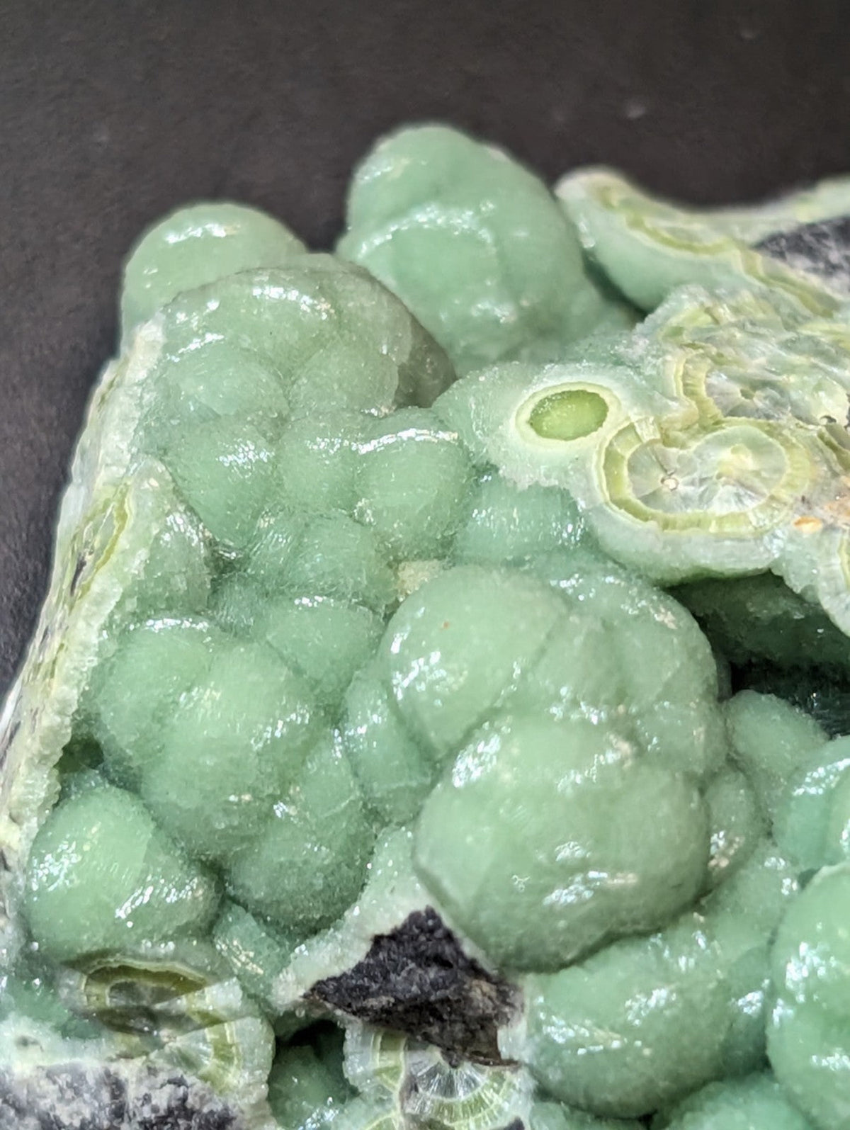 A translucent green geode with rounded, bubble-like formations and a crystalline interior.