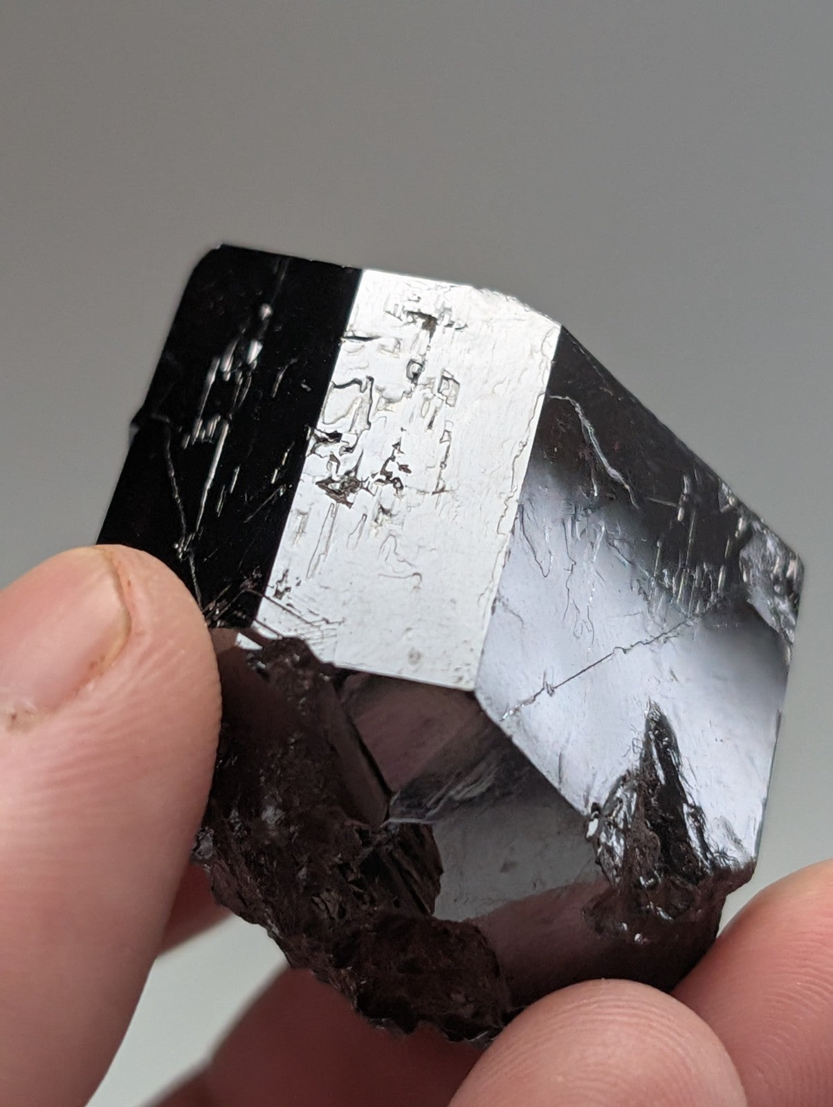 A striking black and silver metallic mineral crystal with a faceted, geometric structure.
