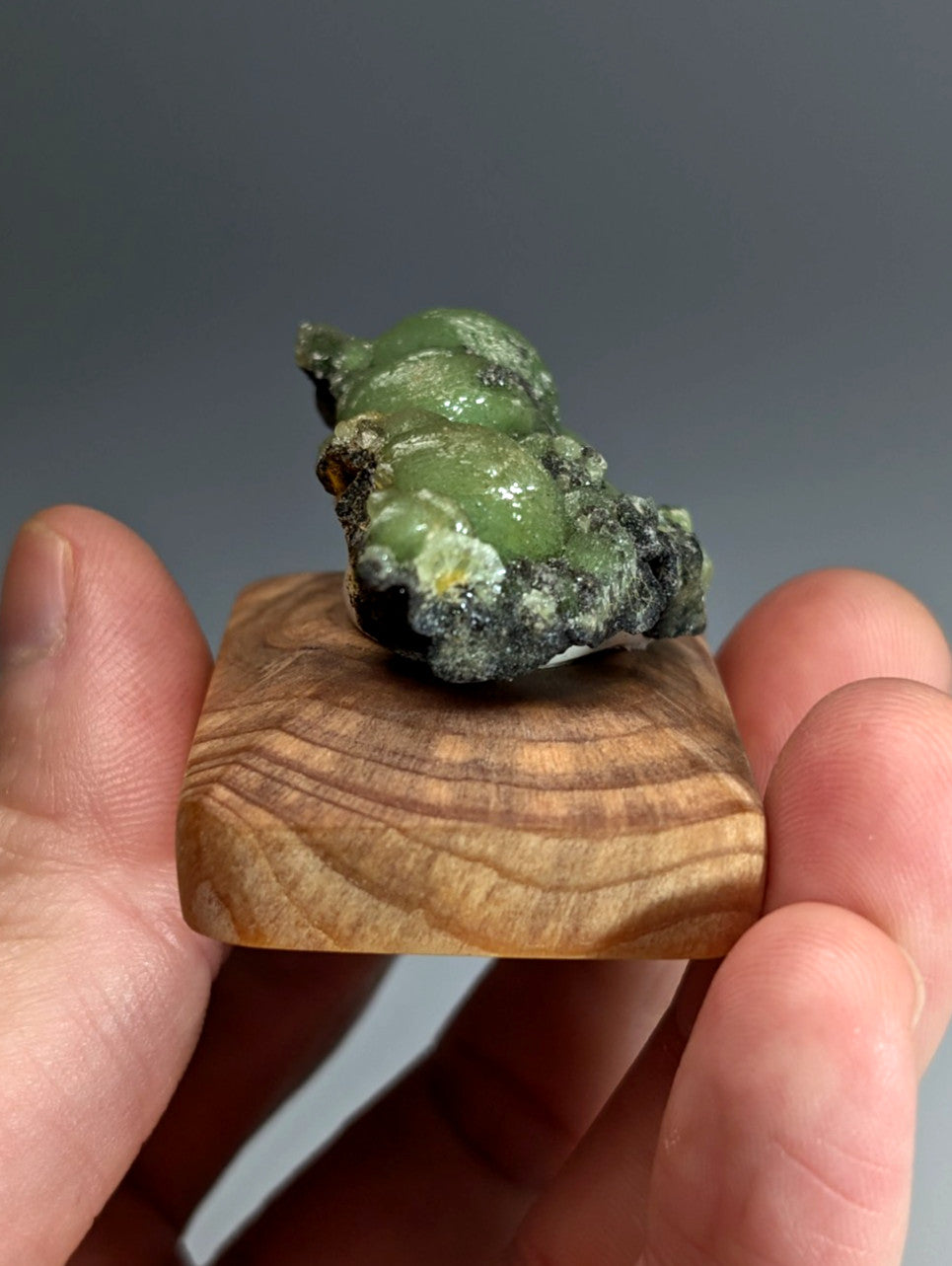 A++ museum grade wavellite with polished green glossy surface and dark matrix on handmade wooden display stand from arkansas