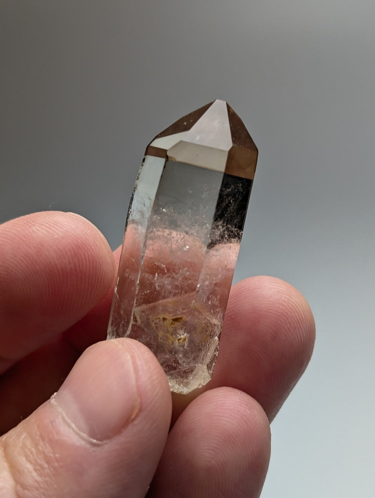 A translucent brownish A+++ natural smoky quartz crystal point with faceted top and internal inclusions from Arkansas USA