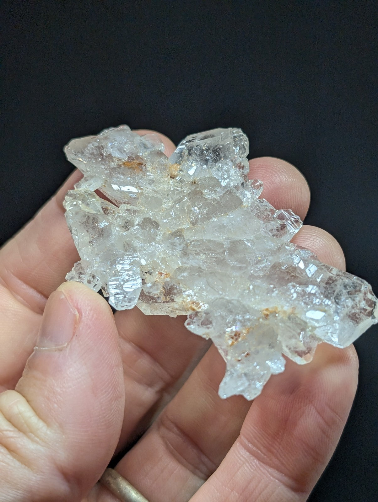 A cluster of clear, translucent quartz crystals with subtle brownish inclusions.