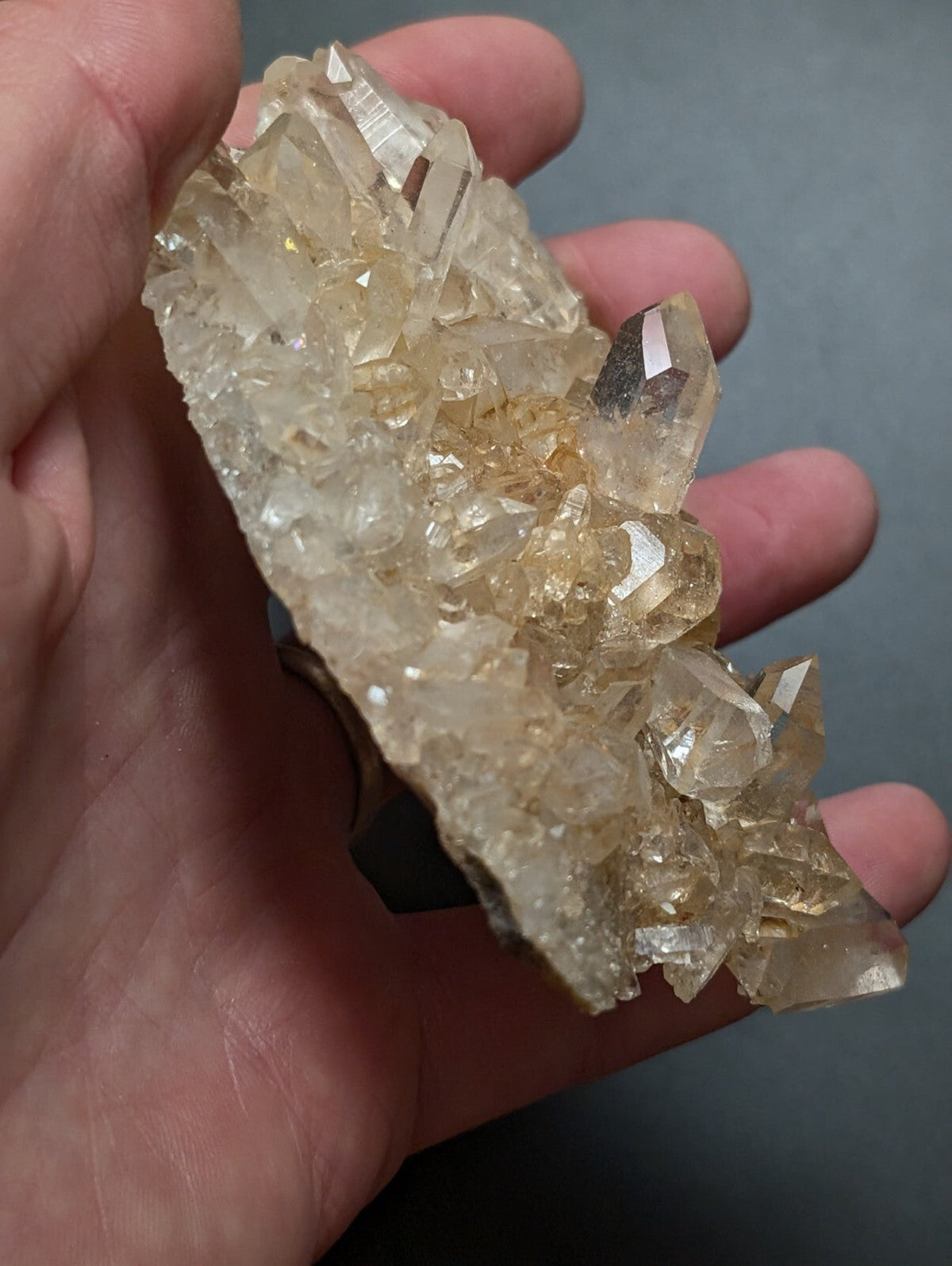 A translucent golden-yellow quartz crystal cluster with sharp, faceted points and a rough, natural texture.