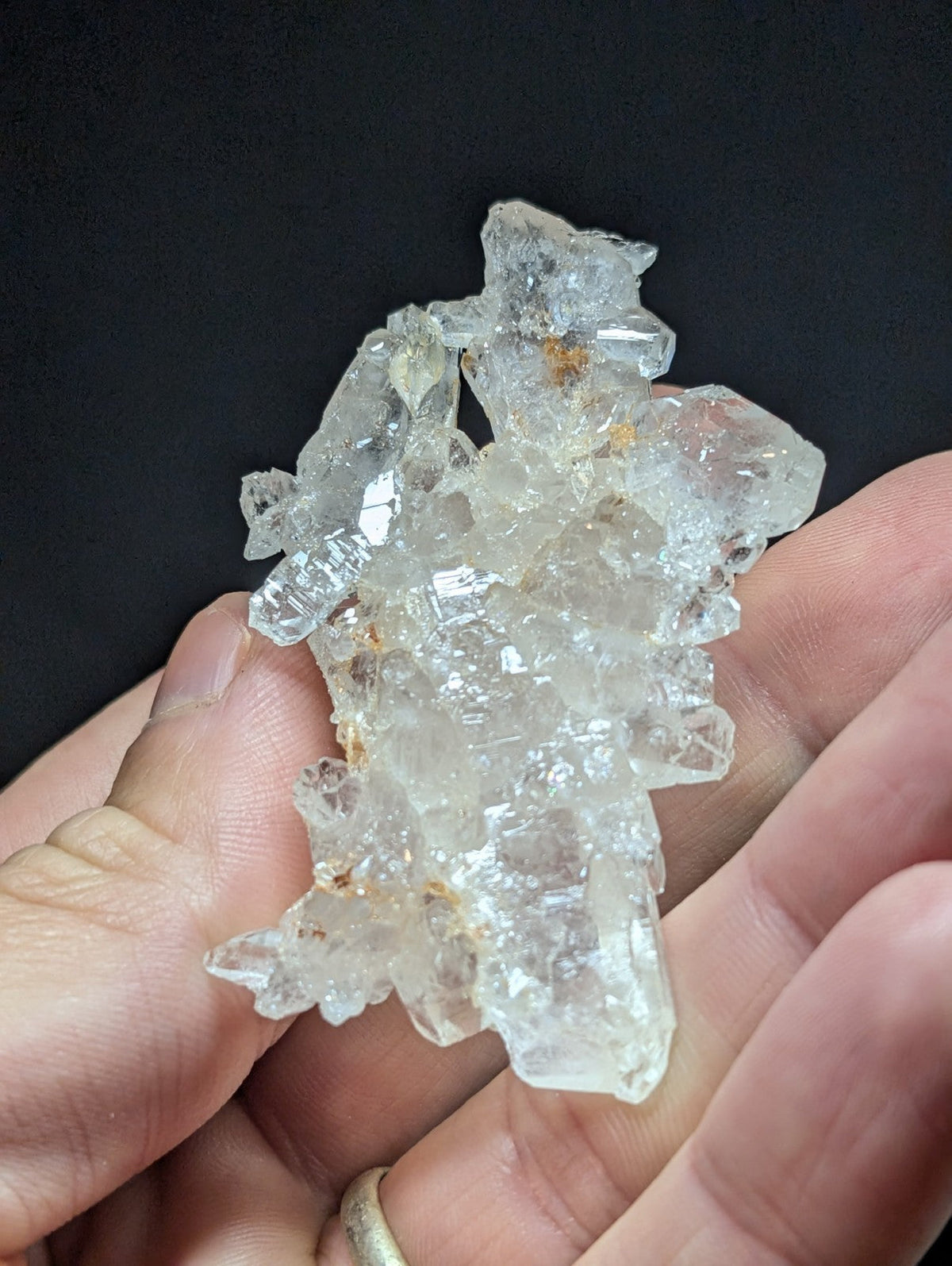 A translucent, clear quartz crystal cluster with jagged edges and subtle amber inclusions.