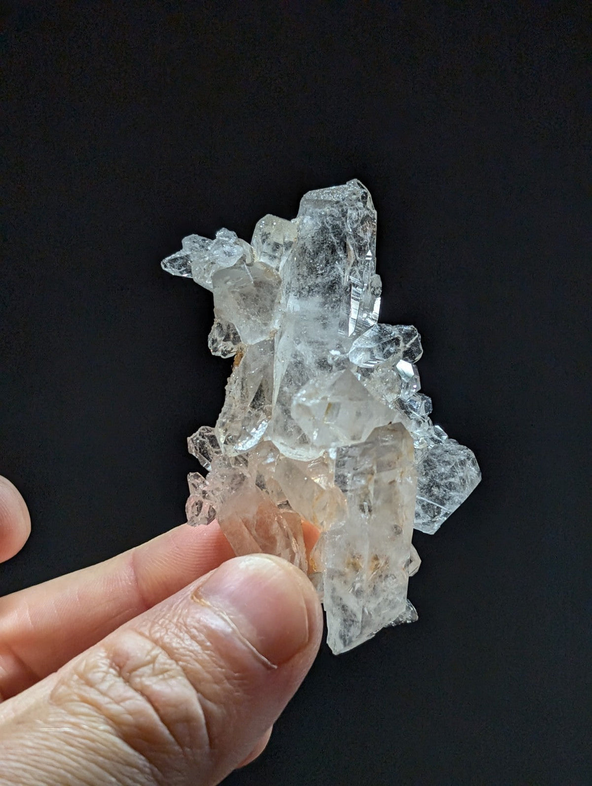 A translucent, clear quartz crystal cluster with jagged edges and a slightly milky appearance.