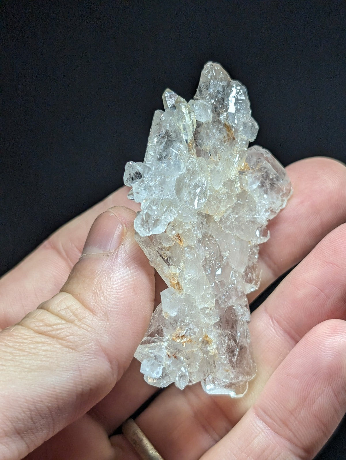 A translucent, clear quartz crystal cluster with sharp, jagged edges and subtle golden inclusions.