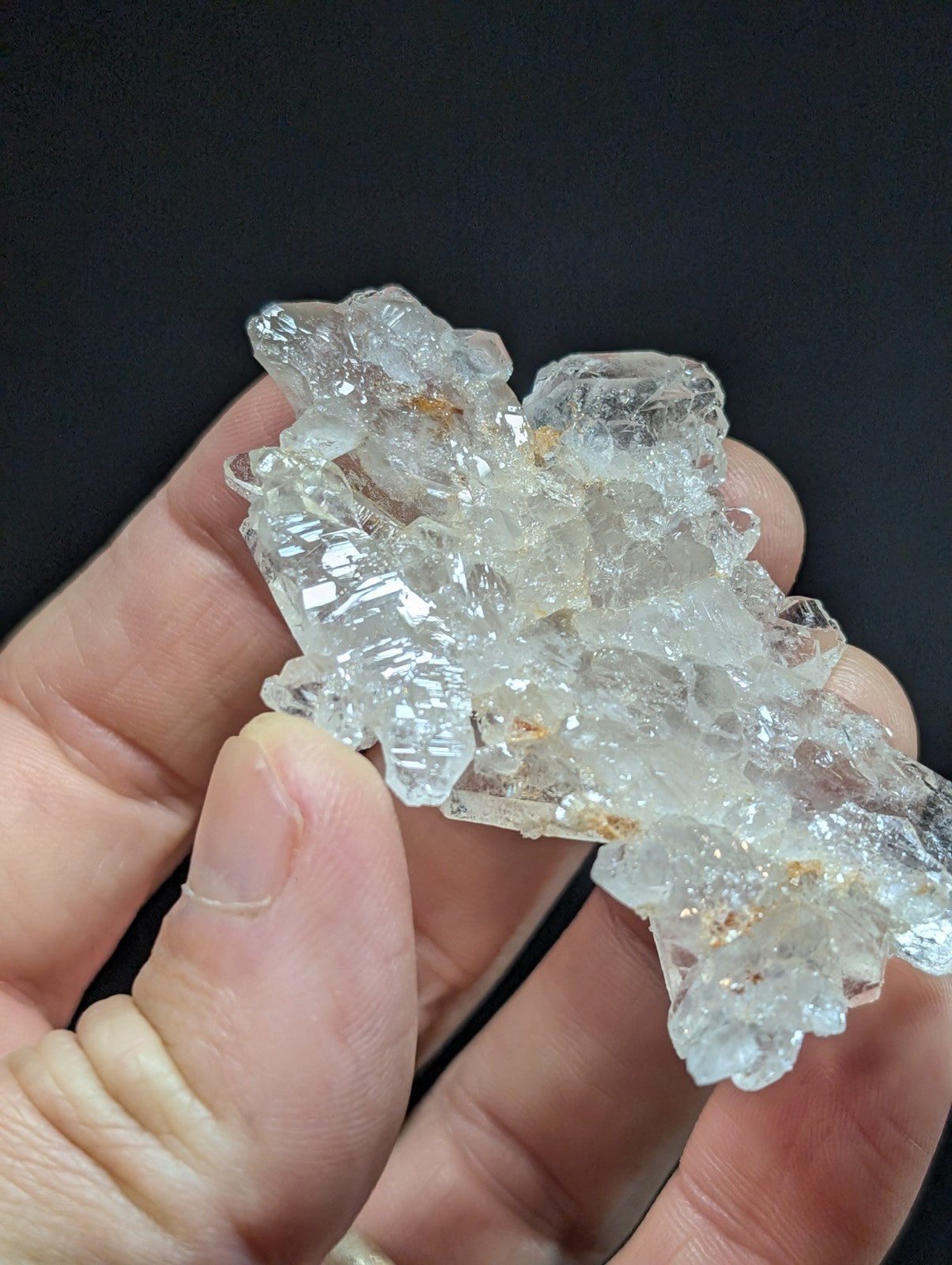 A translucent, clear quartz crystal cluster with sharp edges and facets.