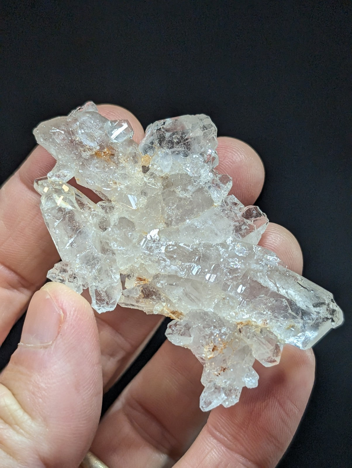 A cluster of clear, translucent quartz crystals with sharp edges and facets.
