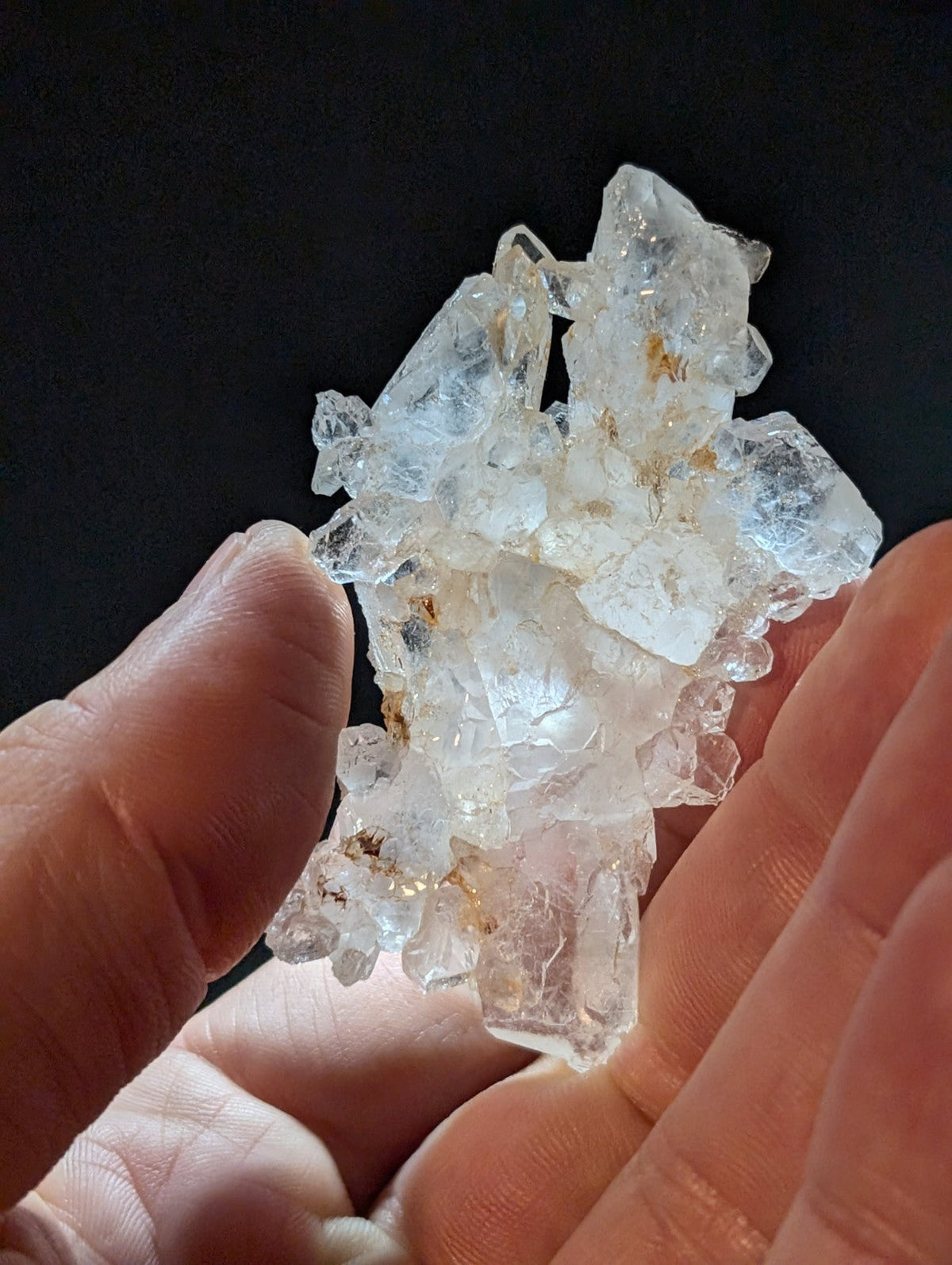 A translucent, crystalline mineral specimen with jagged edges and subtle golden inclusions.