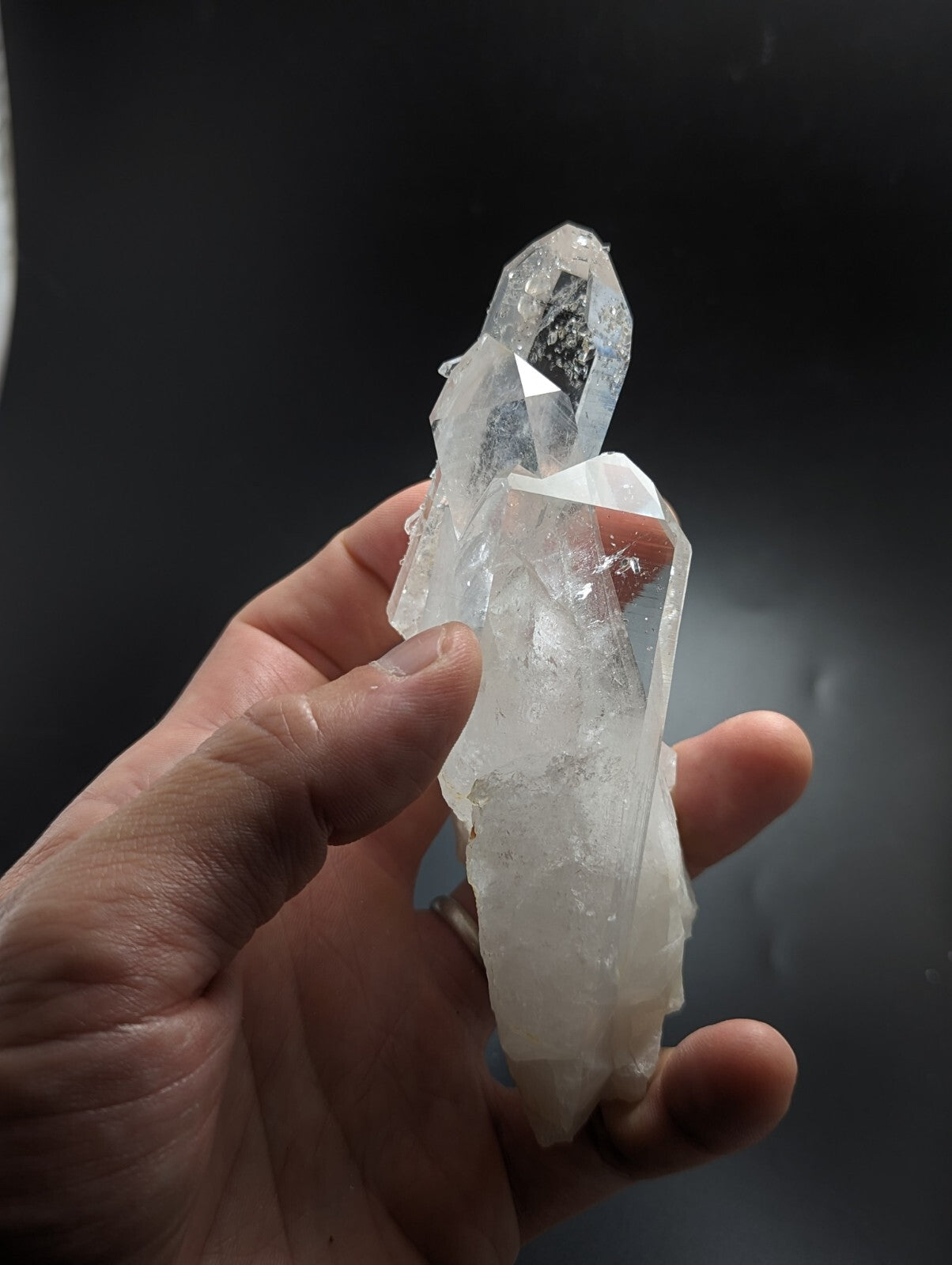A translucent, clear quartz crystal cluster with sharp geometric facets and a slightly cloudy base.