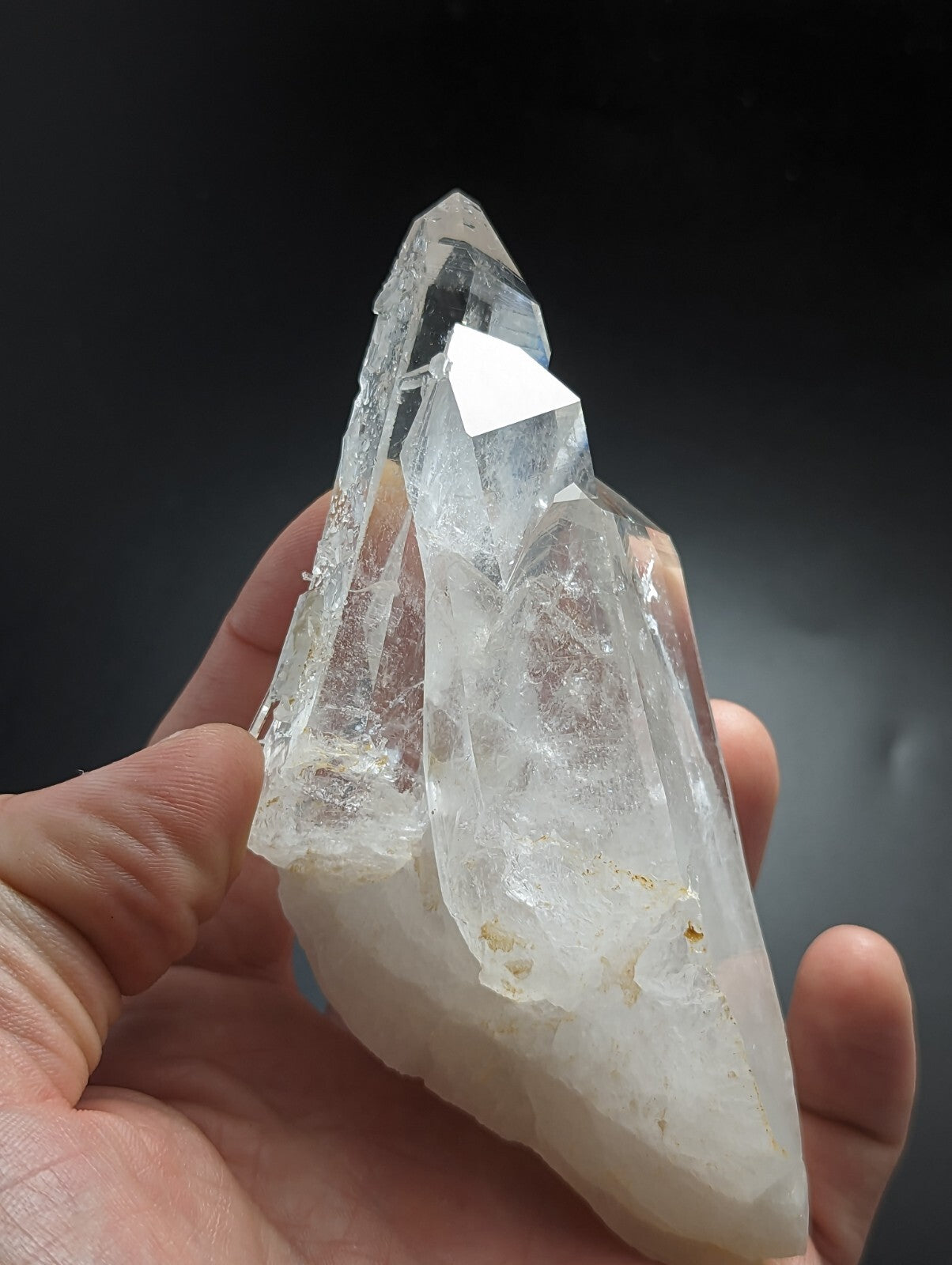 A clear, translucent quartz crystal cluster with sharp geometric facets and a slightly cloudy base.