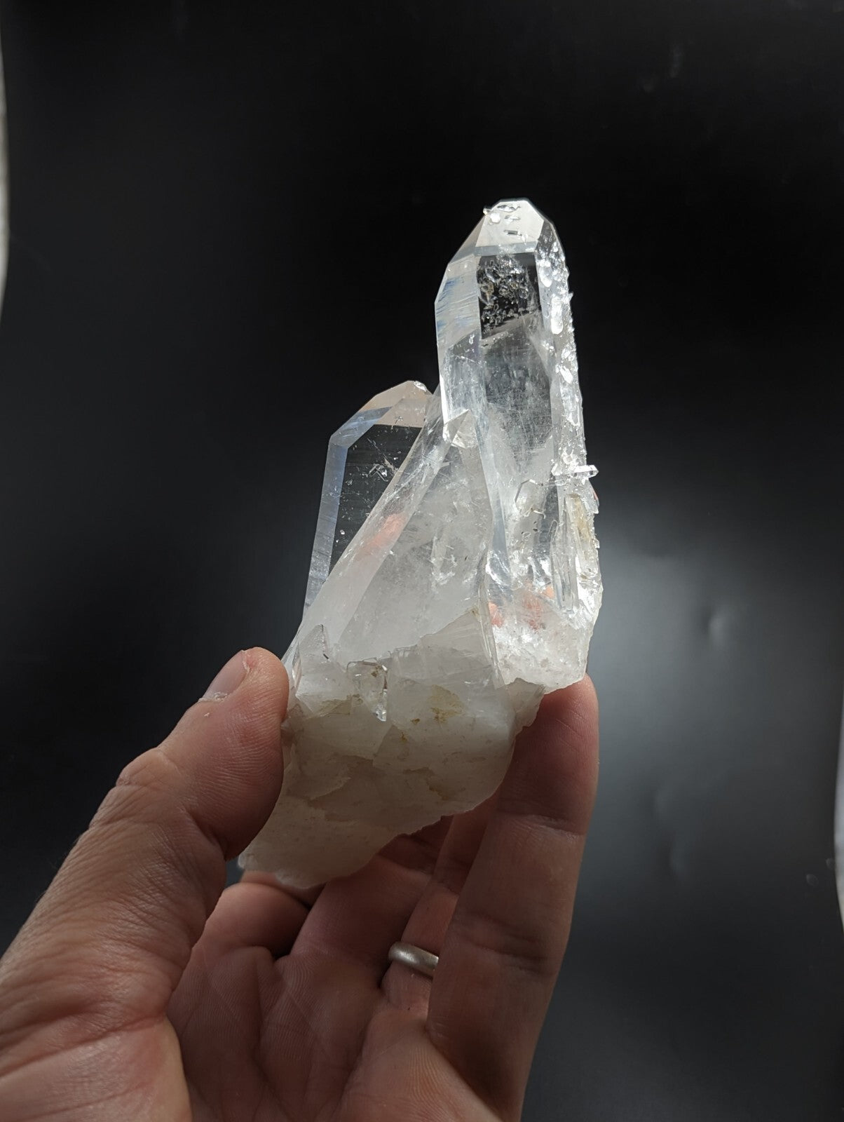A clear, translucent quartz crystal cluster with sharp facets and a slightly cloudy base.