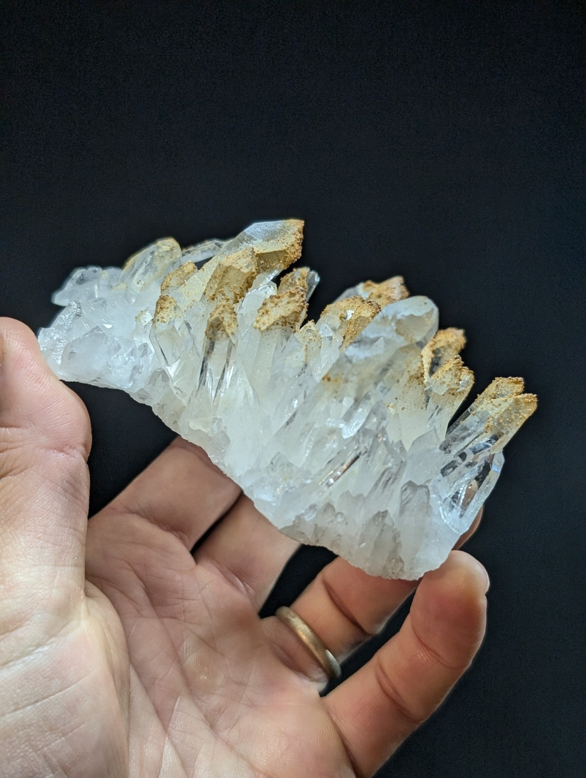 A translucent white quartz crystal cluster with golden-brown mineral inclusions.