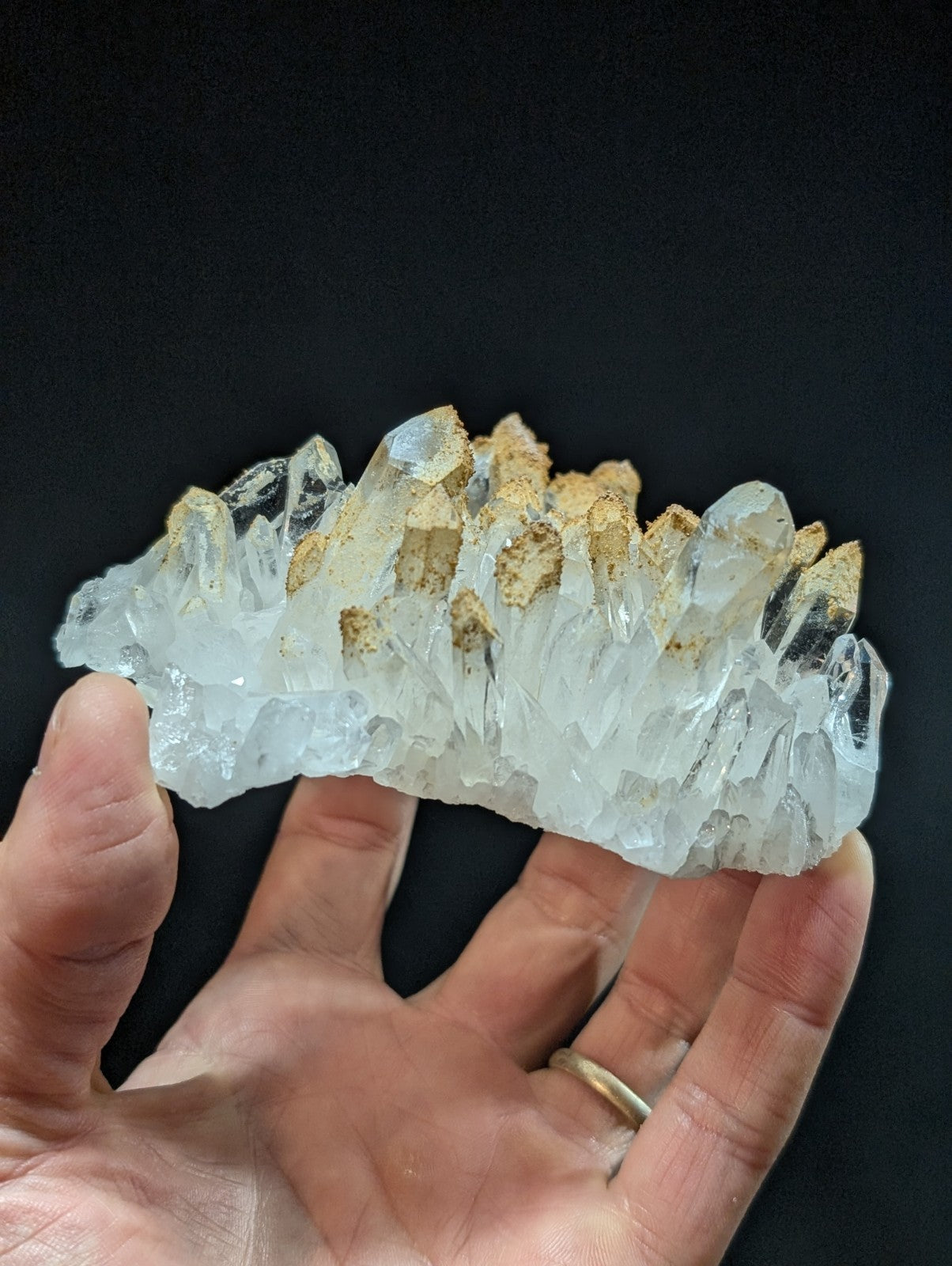A translucent white quartz crystal cluster with golden-brown mineral inclusions.