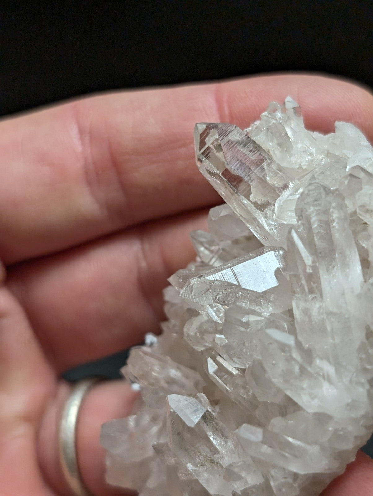 A clear, translucent quartz crystal cluster with sharp, pointed facets and a natural, rugged formation.