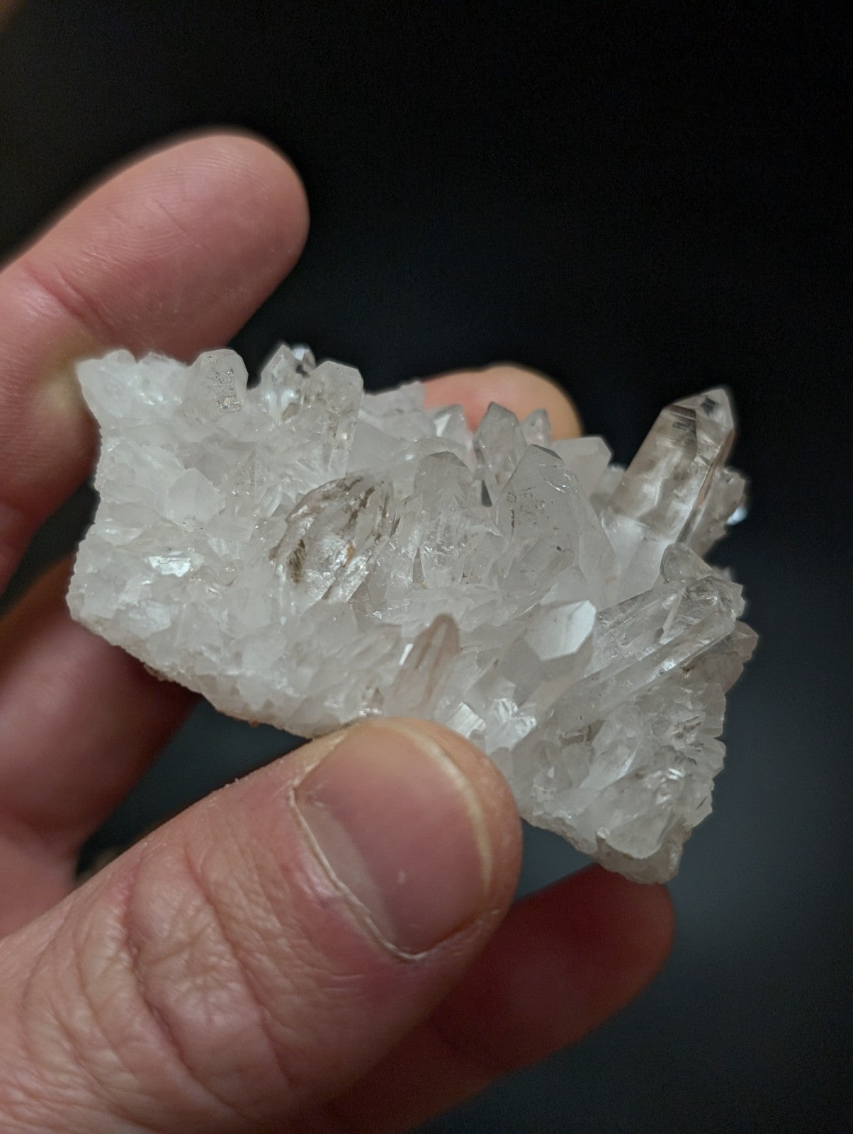 A translucent white quartz crystal cluster with sharp, faceted points and a natural, rugged texture.