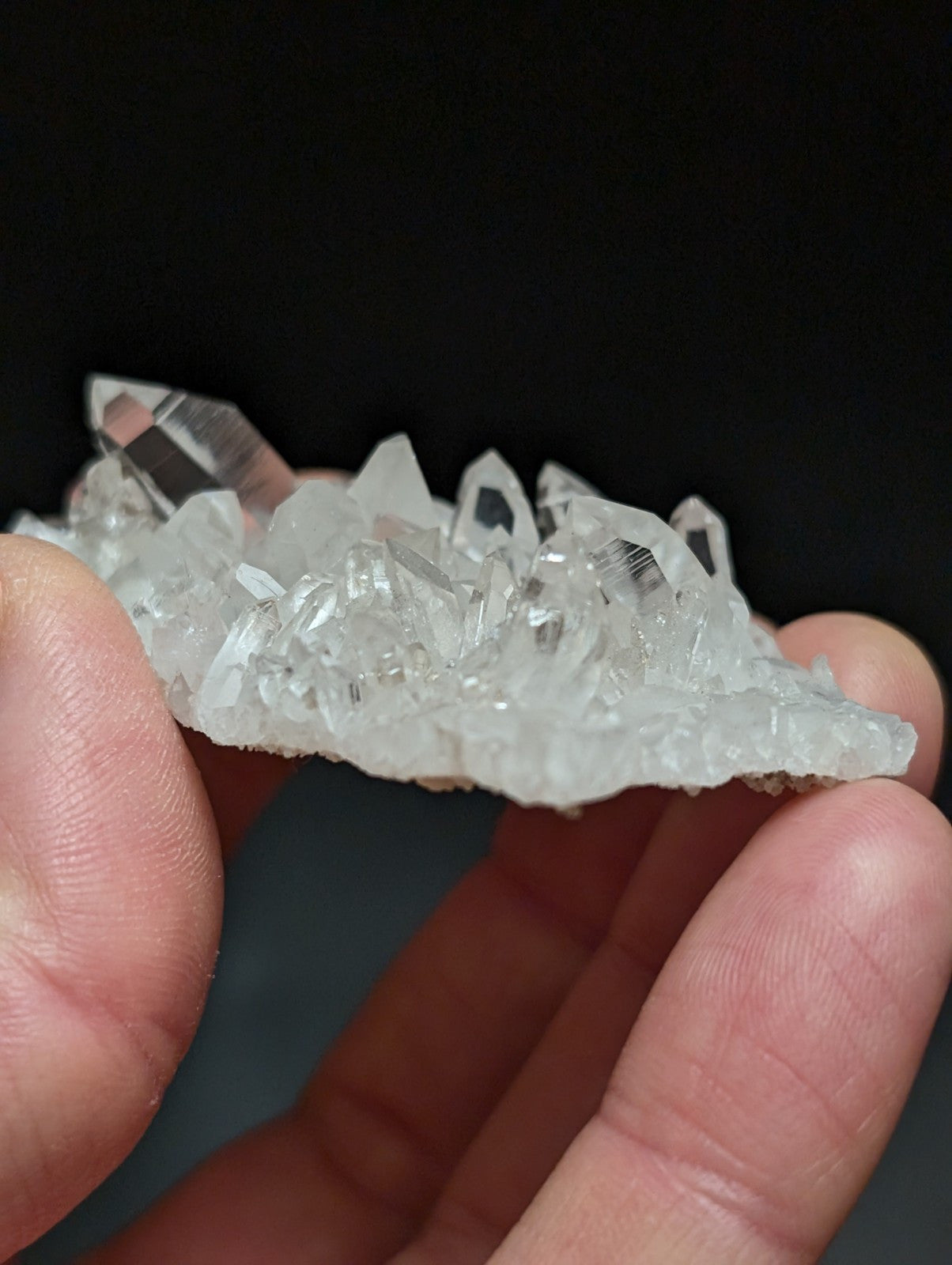 A translucent white quartz crystal cluster with sharp, faceted points and a natural, rugged base.