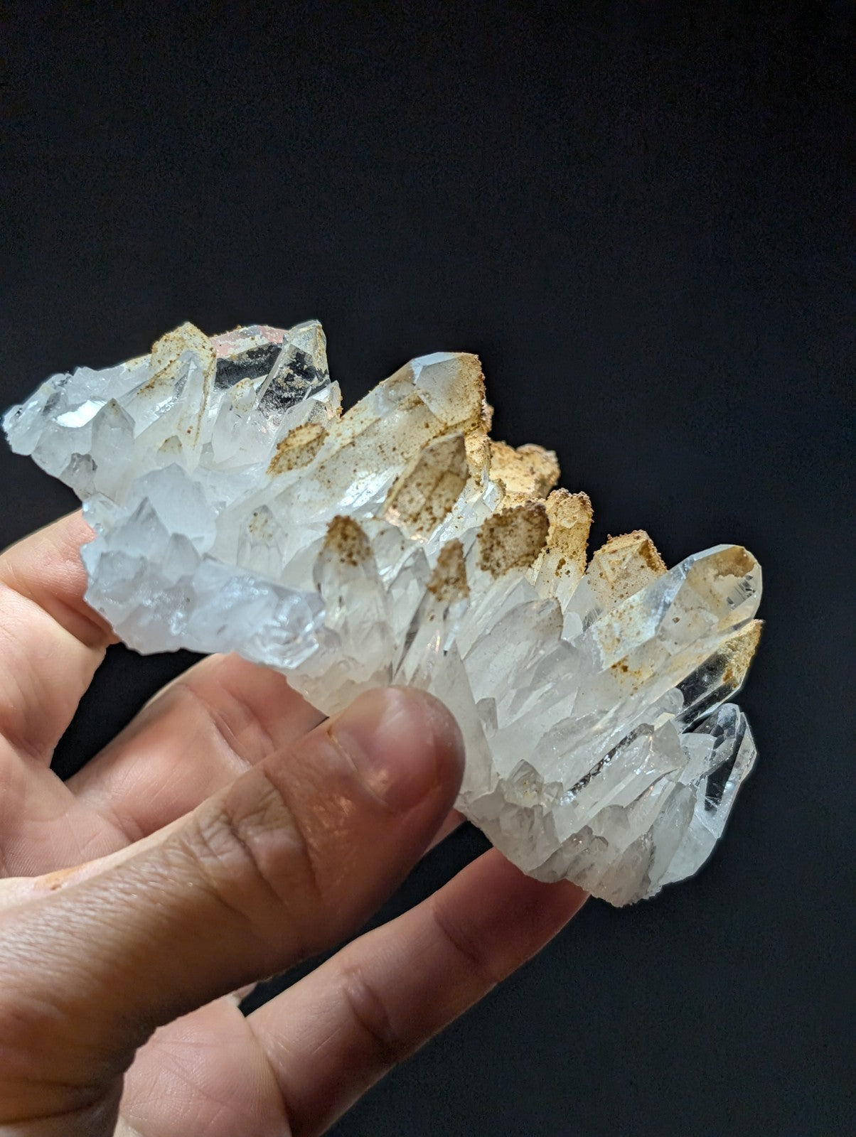 A translucent white quartz crystal cluster with golden-brown mineral inclusions.