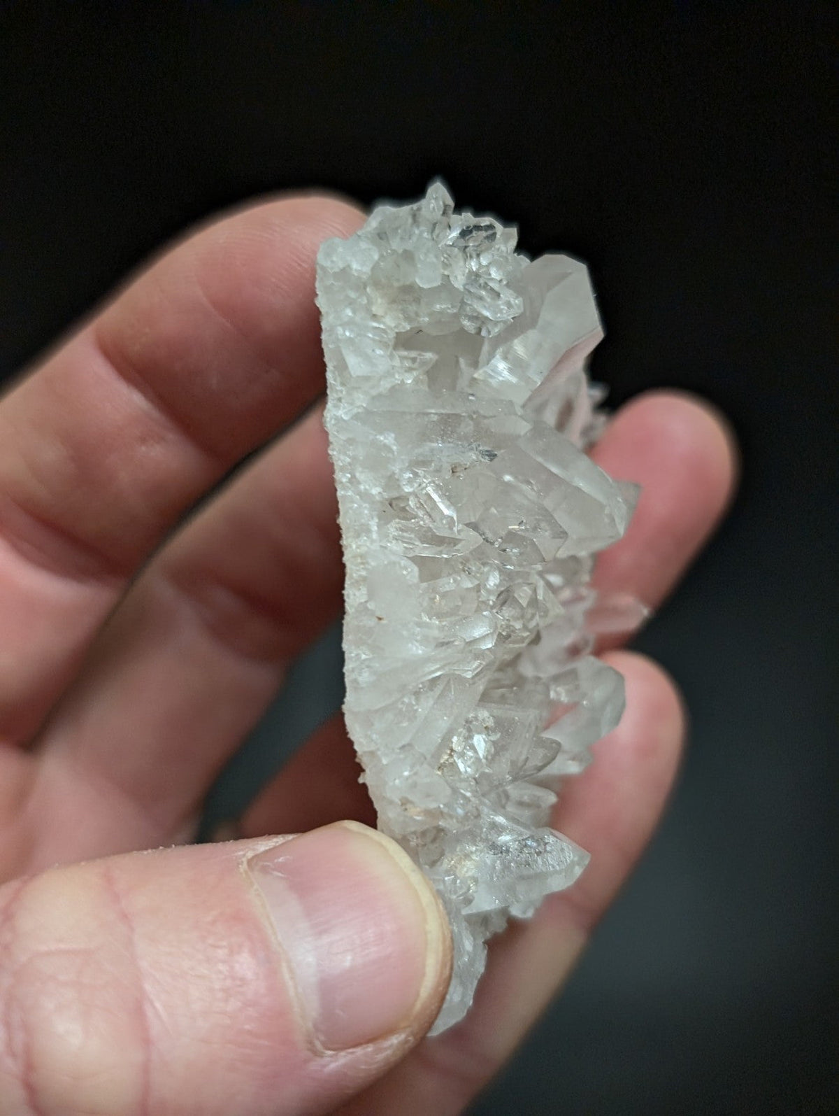 A translucent, clear quartz crystal cluster with sharp, jagged edges and a natural, irregular formation.