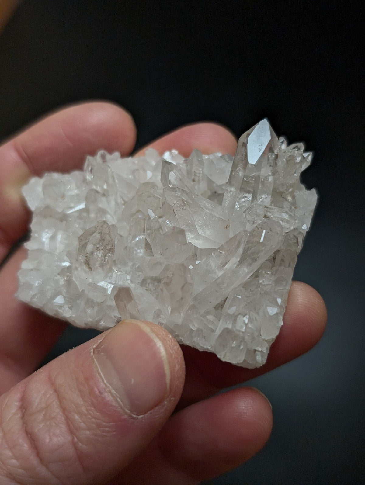 A translucent white quartz crystal cluster with sharp, faceted points and a rough, natural texture.