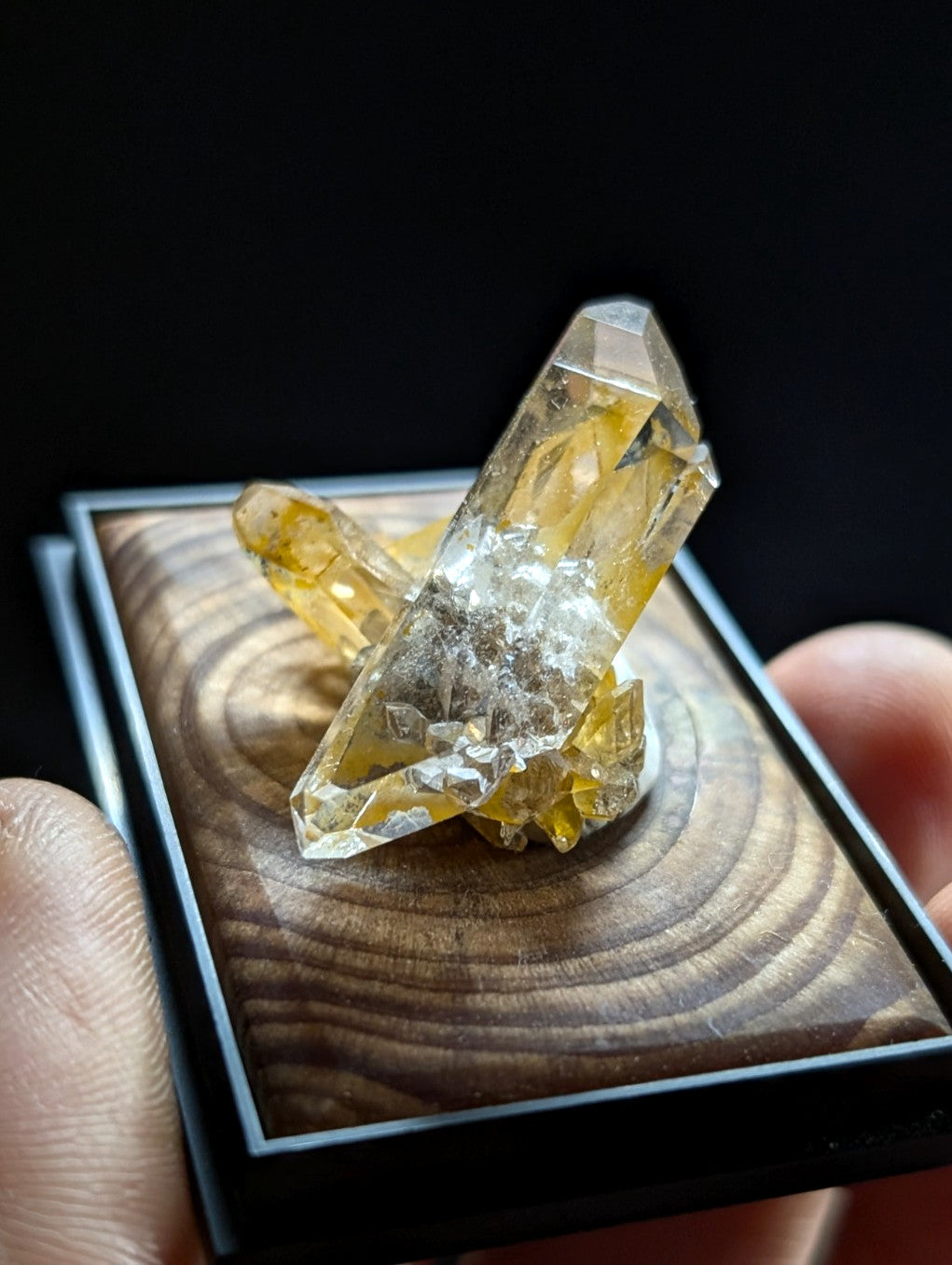 A translucent yellow crystal cluster with sharp, faceted points and a base of white crystalline material.