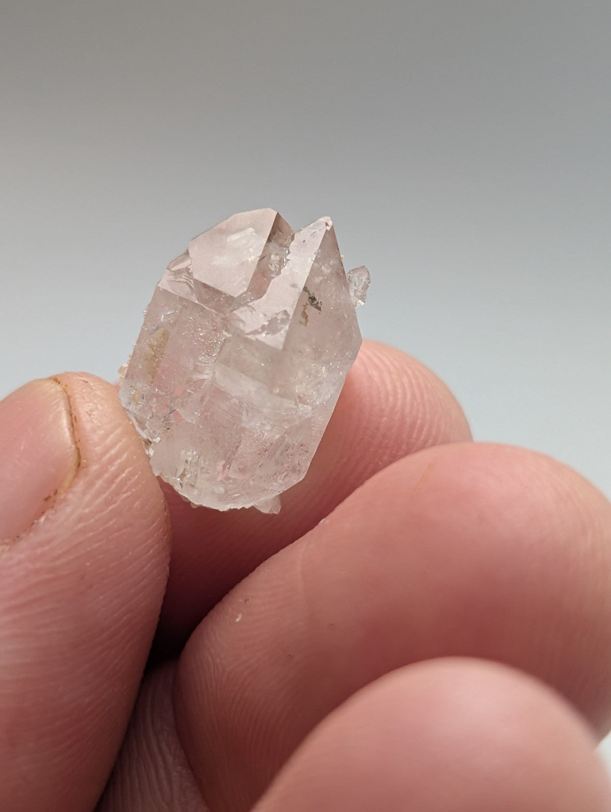 A clear, translucent quartz crystal with sharp geometric facets and subtle internal inclusions.