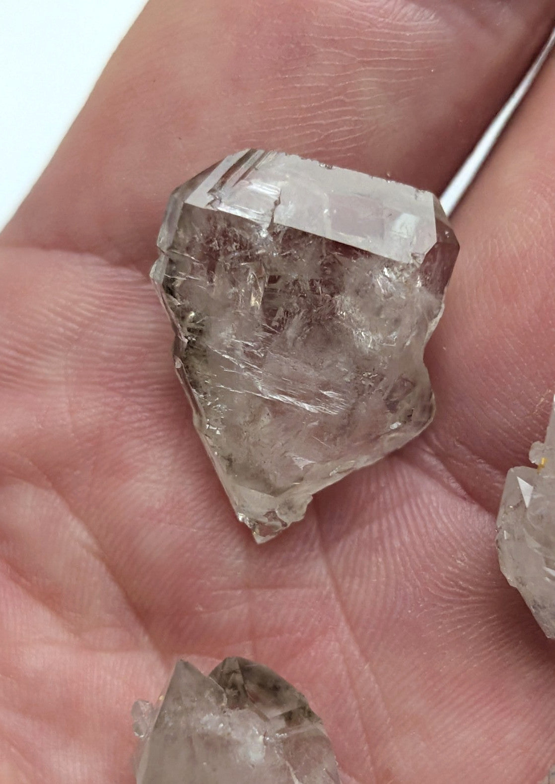 A translucent, faceted quartz crystal with visible internal inclusions and a slightly rough, natural edge.