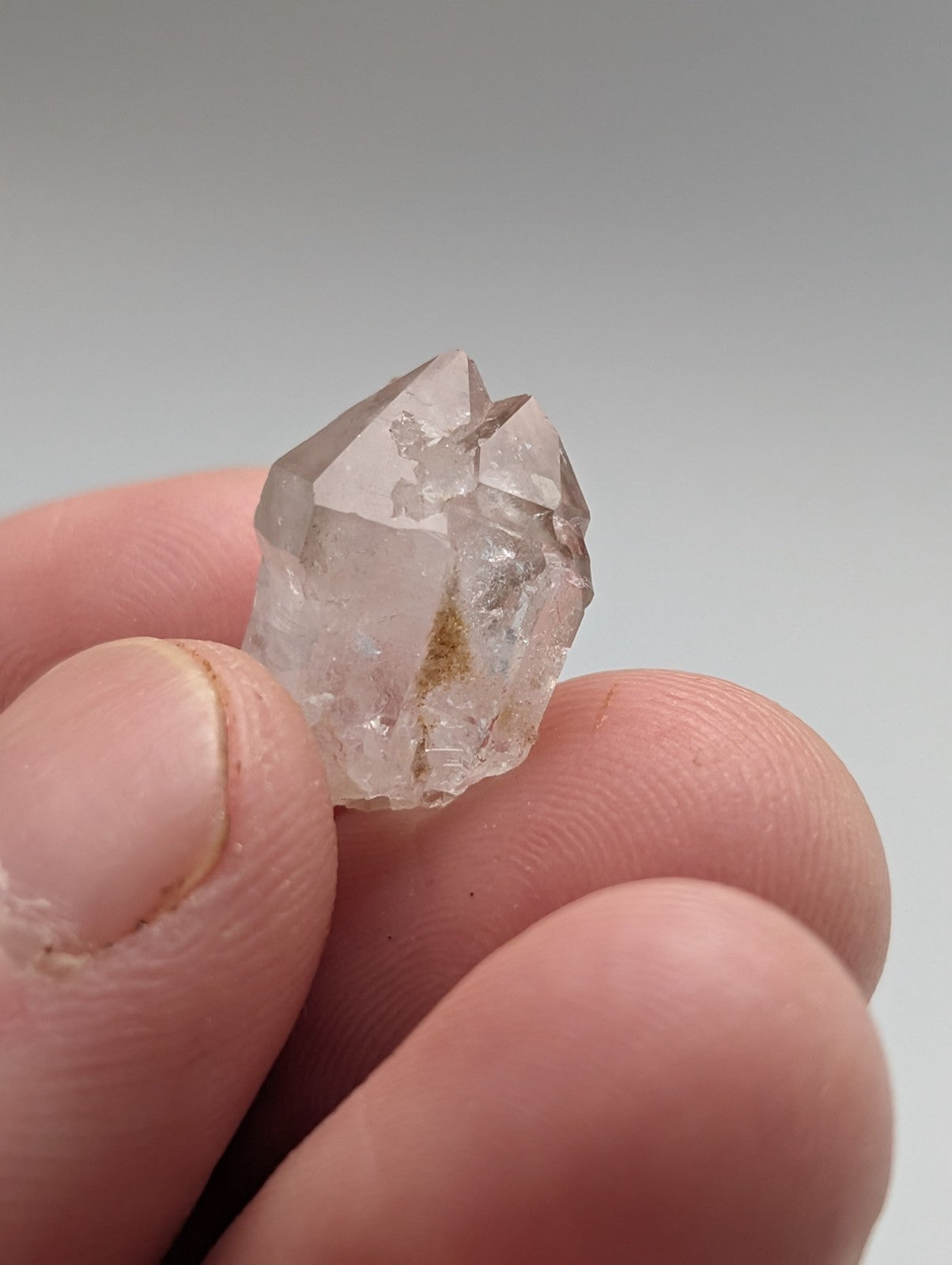 A translucent, clear quartz crystal with a pointed tip and natural inclusions.