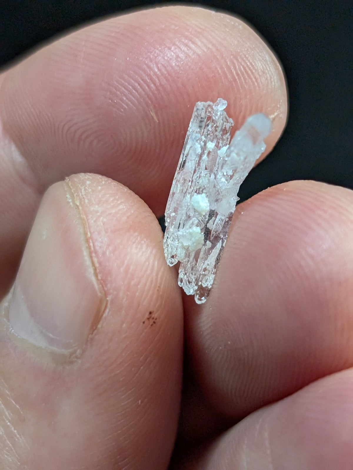 A translucent, crystalline shard with jagged edges and a slightly cloudy texture.