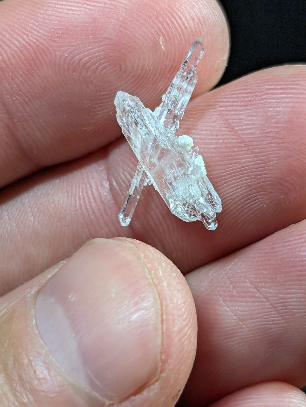 A translucent, crystalline mineral specimen with sharp, angular facets and a pale, glassy sheen.