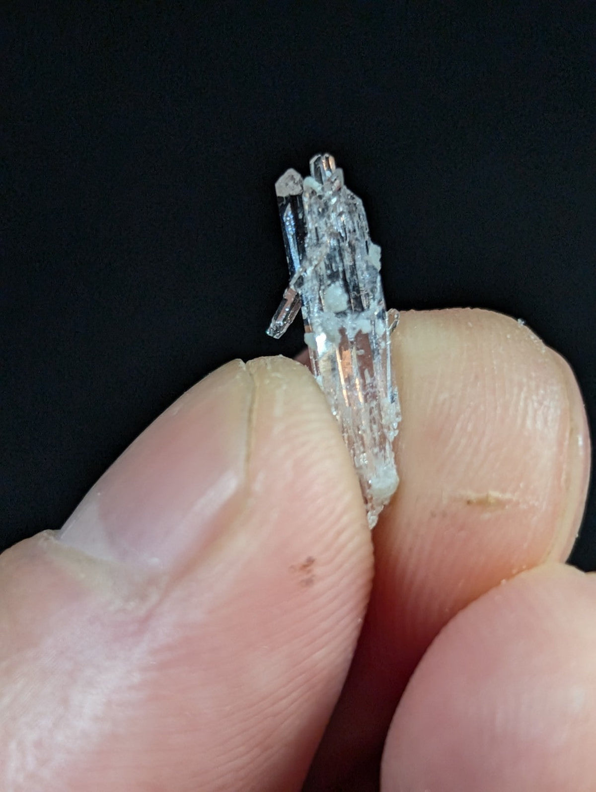 A translucent, crystalline mineral specimen with a jagged, multi-faceted structure and subtle internal reflections.
