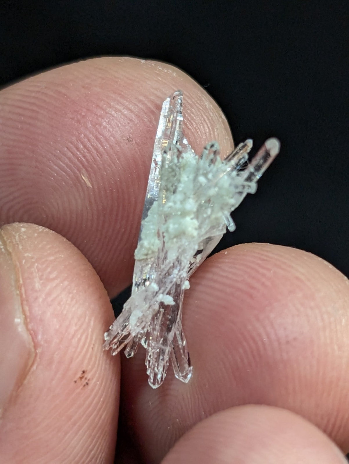 A translucent, crystalline mineral specimen with clear, sharp facets and a subtle greenish tint at its base.