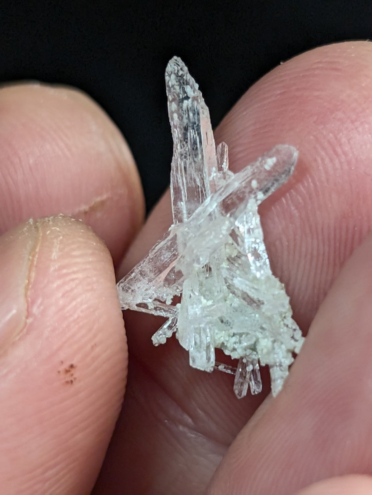 A translucent, crystalline mineral specimen with sharp, jagged facets and a clear, glassy appearance.