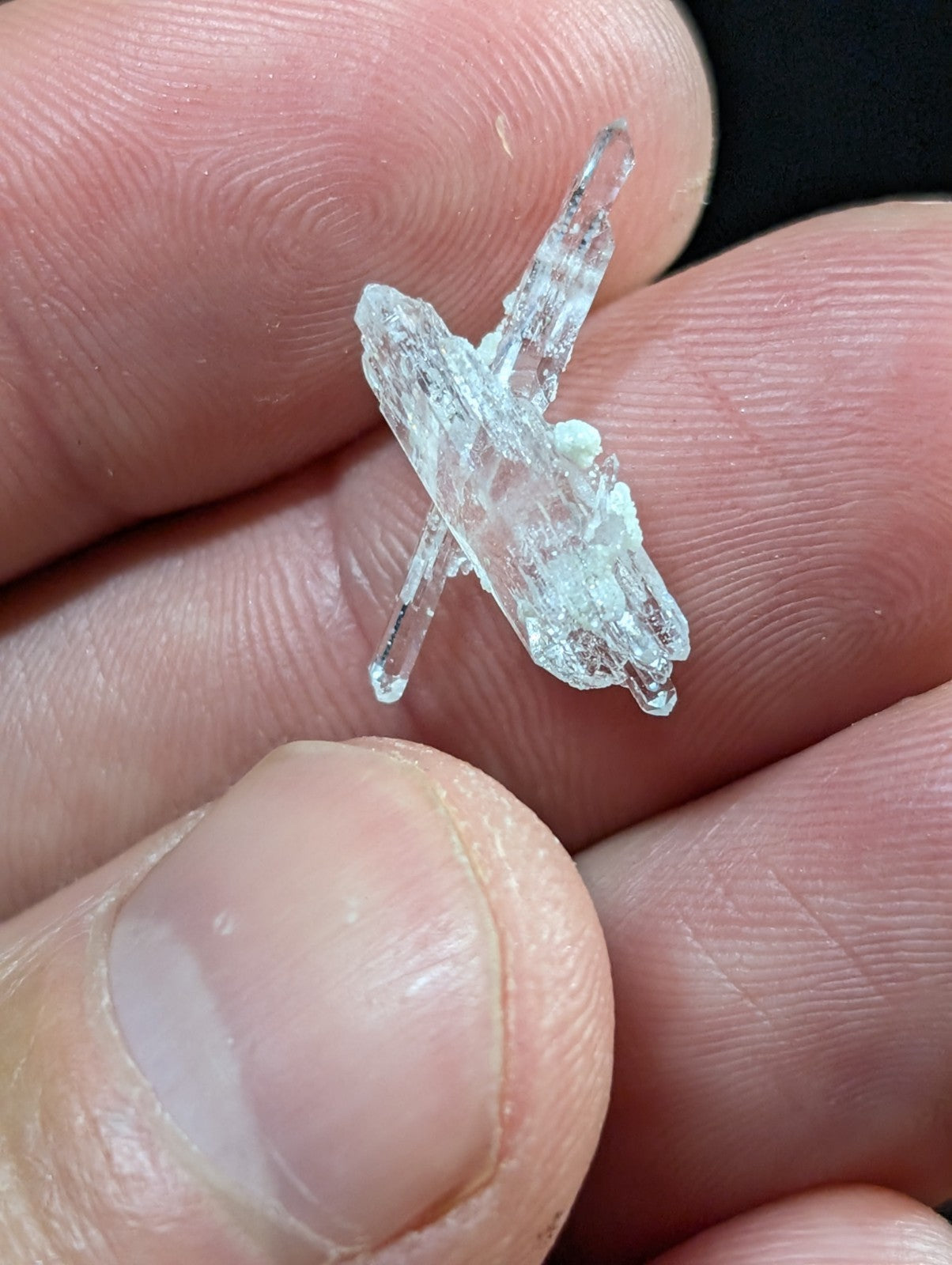 A translucent, crystalline mineral specimen with sharp, angular facets and a pale, glassy sheen.