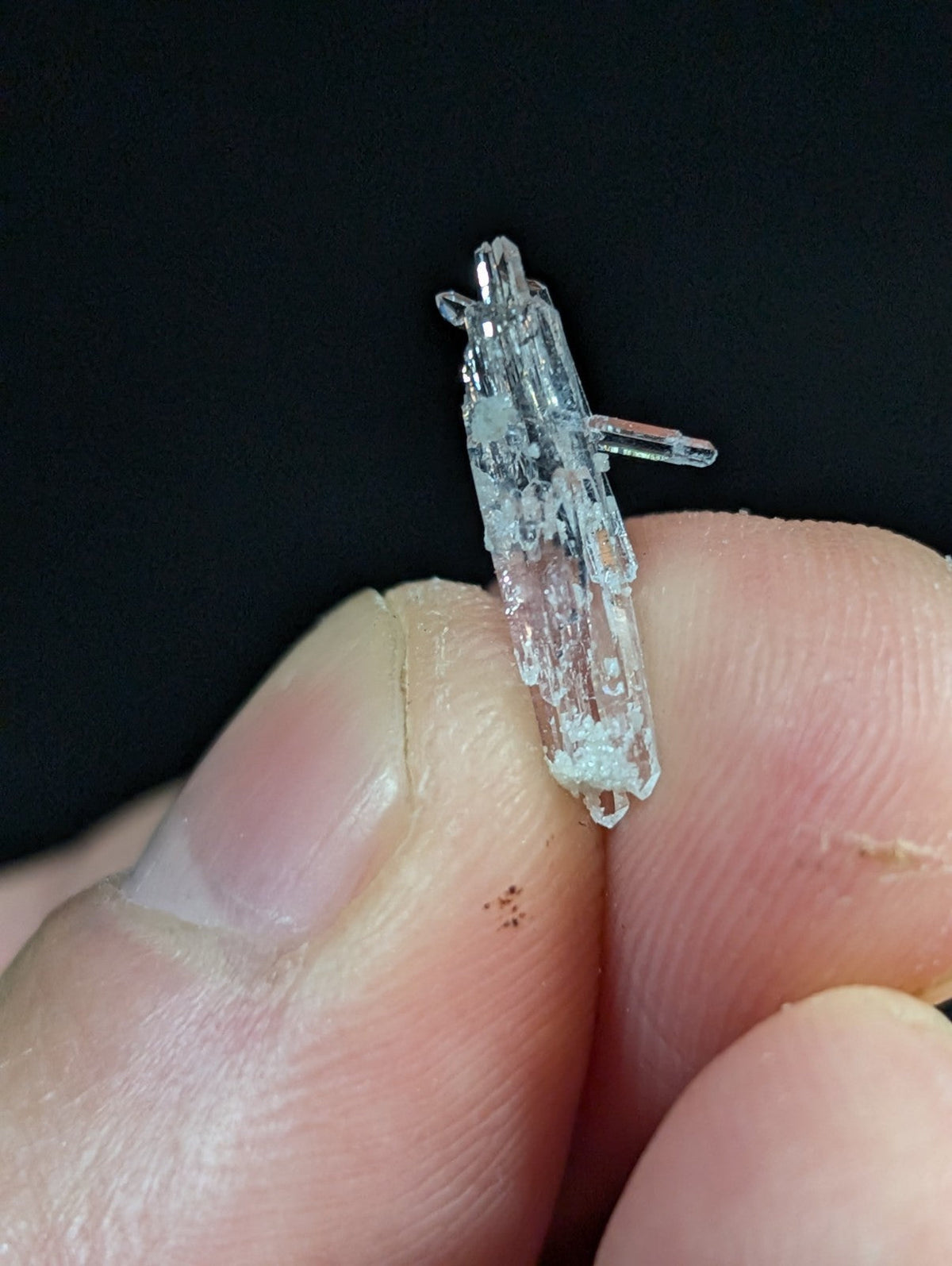 A translucent, crystalline mineral specimen with a jagged, multi-faceted structure and subtle internal inclusions.