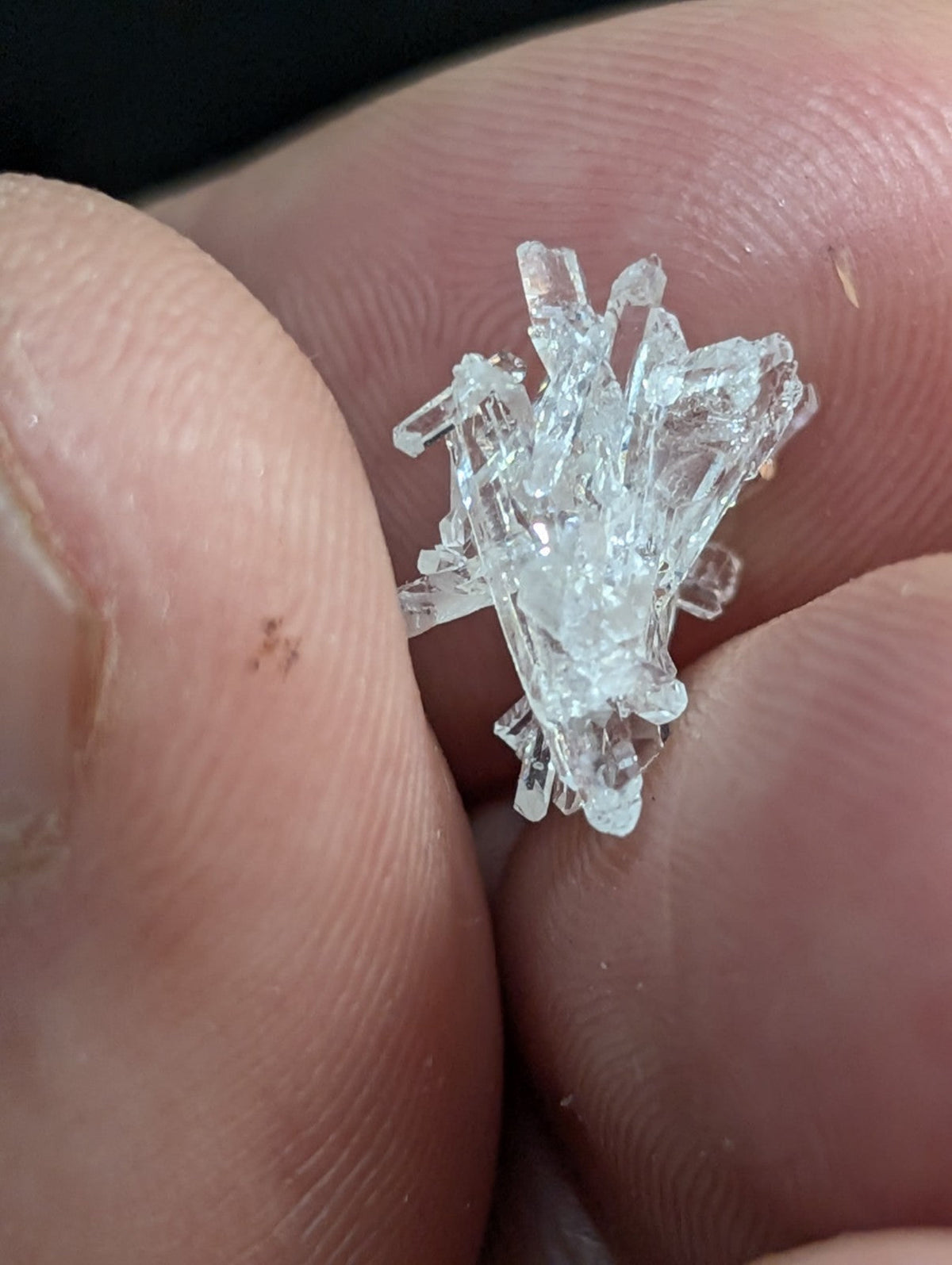 A clear, crystalline mineral specimen with sharp, jagged facets and a translucent appearance.