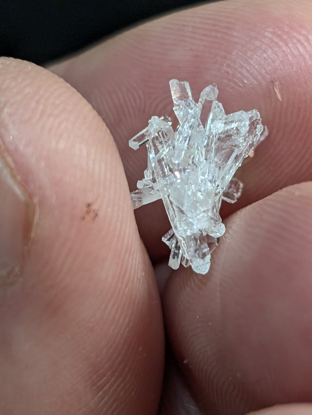 A clear, crystalline mineral specimen with sharp, jagged facets and a translucent appearance.