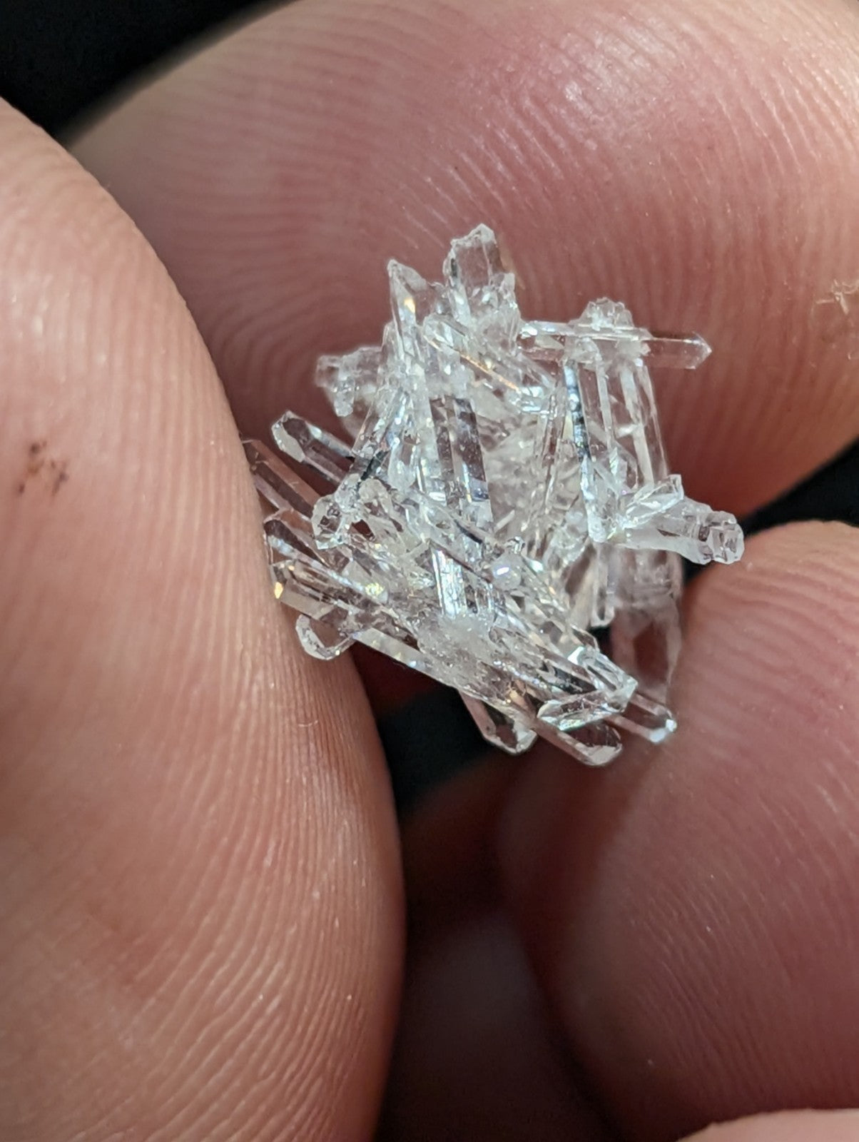 A cluster of clear, transparent quartz crystals with sharp, faceted edges and a natural, irregular growth pattern.