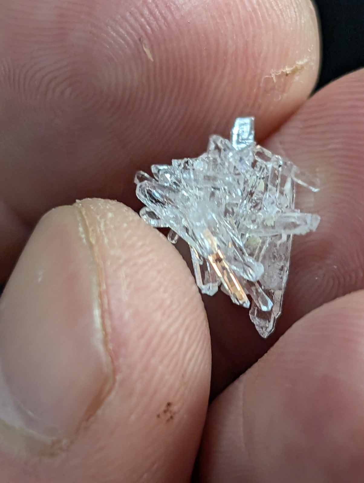 A cluster of clear, translucent quartz crystals with sharp, angular facets and a natural, irregular formation.