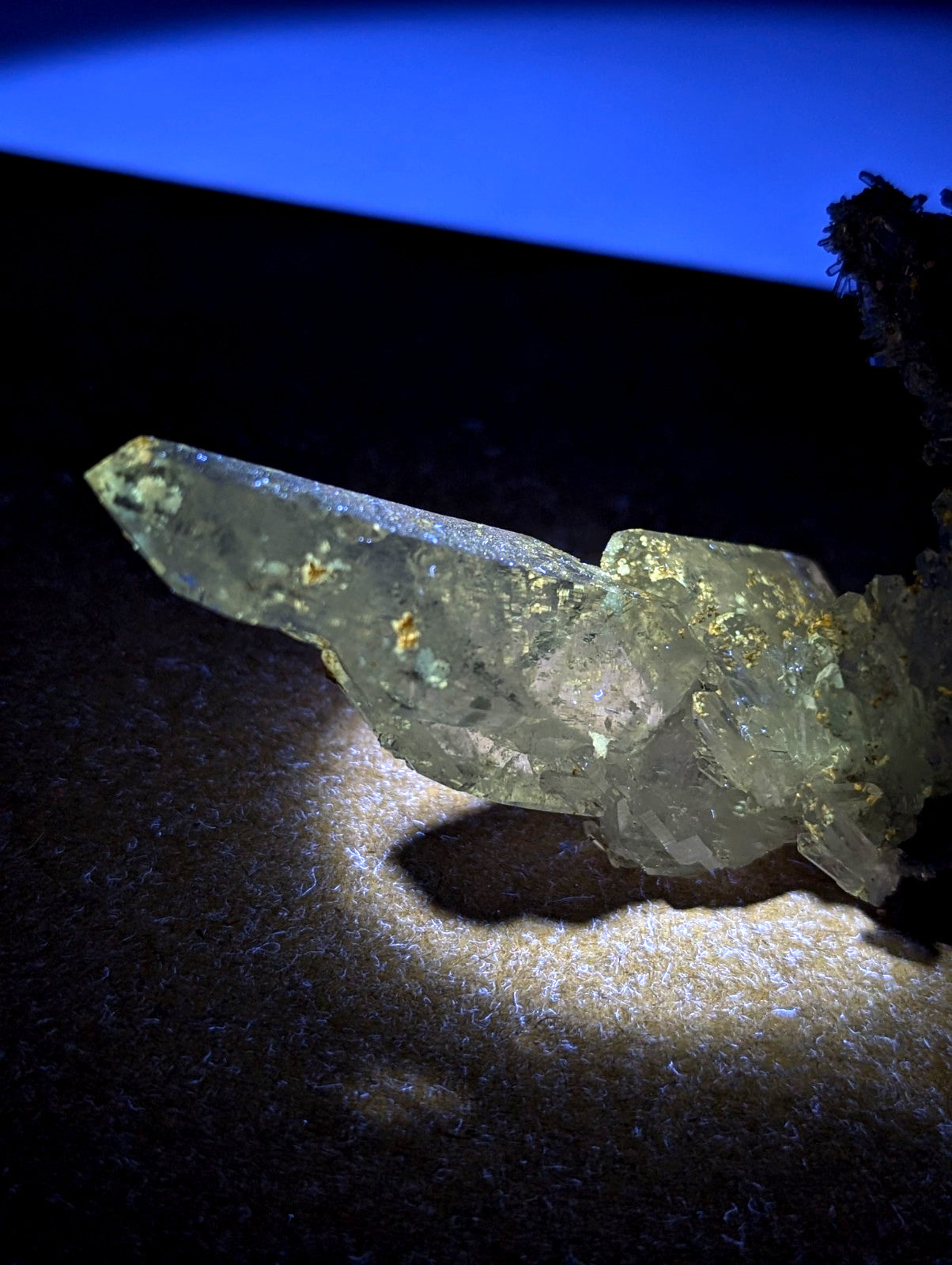 A pale green translucent quartz crystal with golden uv reactive cookeite inclusions from Jeffrey Quarry Arkansas