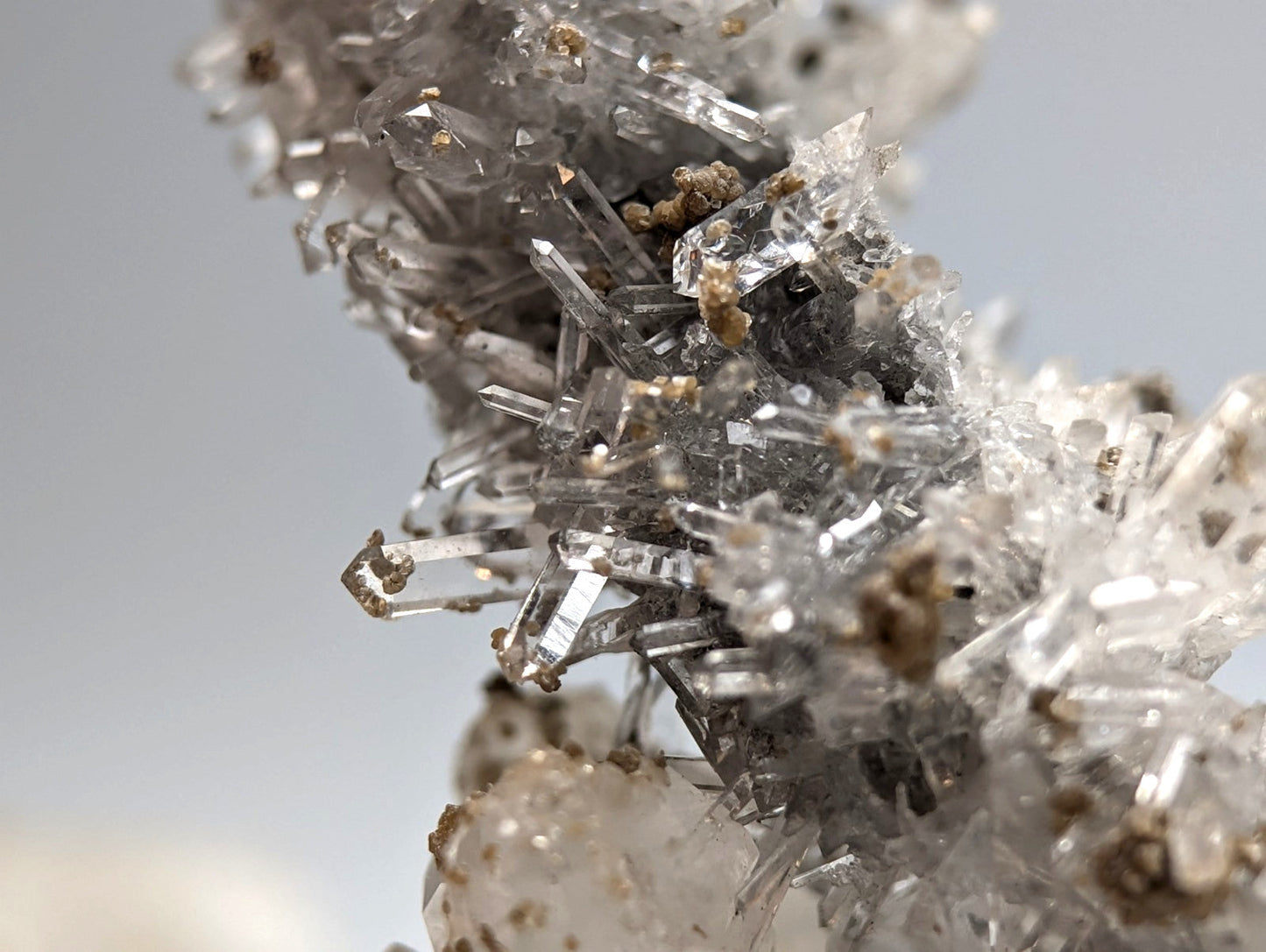 A cluster of clear translucent quartz crystals with golden mineral inclusions from jeffrey quarry arkansas