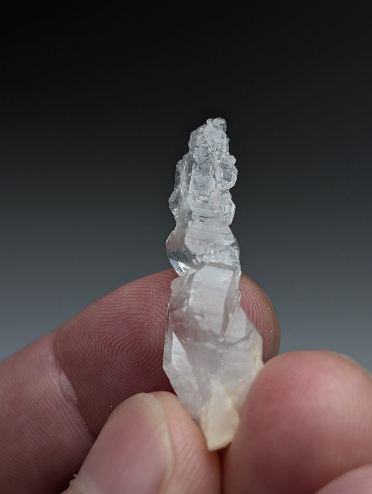 A translucent clear quartz crystal with a rough jagged surface and layered growth from garland county arkansas usa