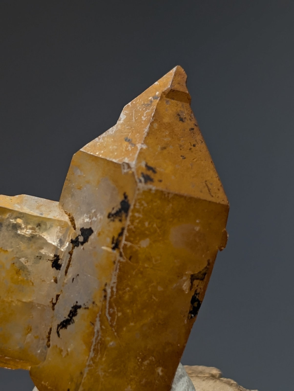 A+ unique quartz crystal with sharp angular facets and dark inclusions on a natural wood base from garland county arkansas