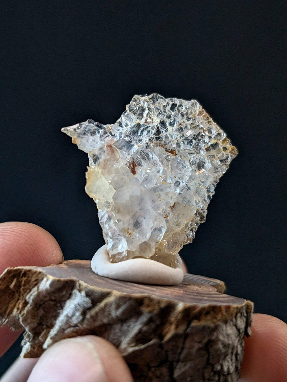 A translucent, crystalline mineral specimen with a rough, jagged surface and subtle golden-yellow inclusions.