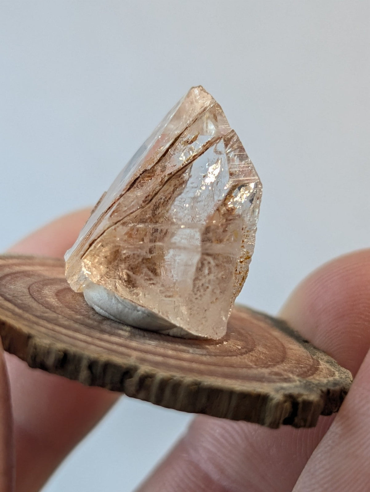 A translucent, light amber-colored crystal with visible internal inclusions and a faceted surface.